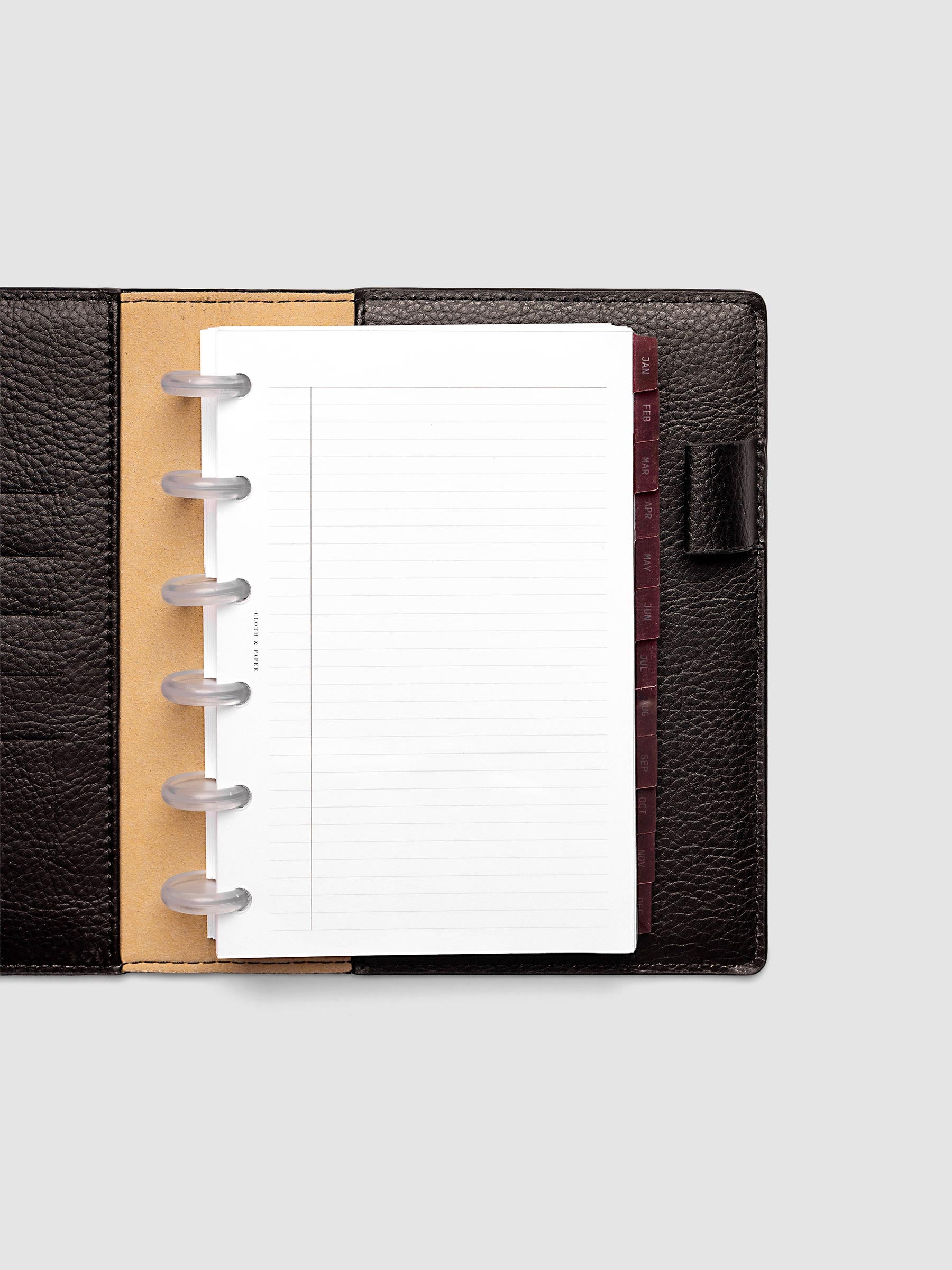 CP Petite 6-Disc Punch Ultra-Thin Monthly Dividers in deep red shown tabbed inside a planner