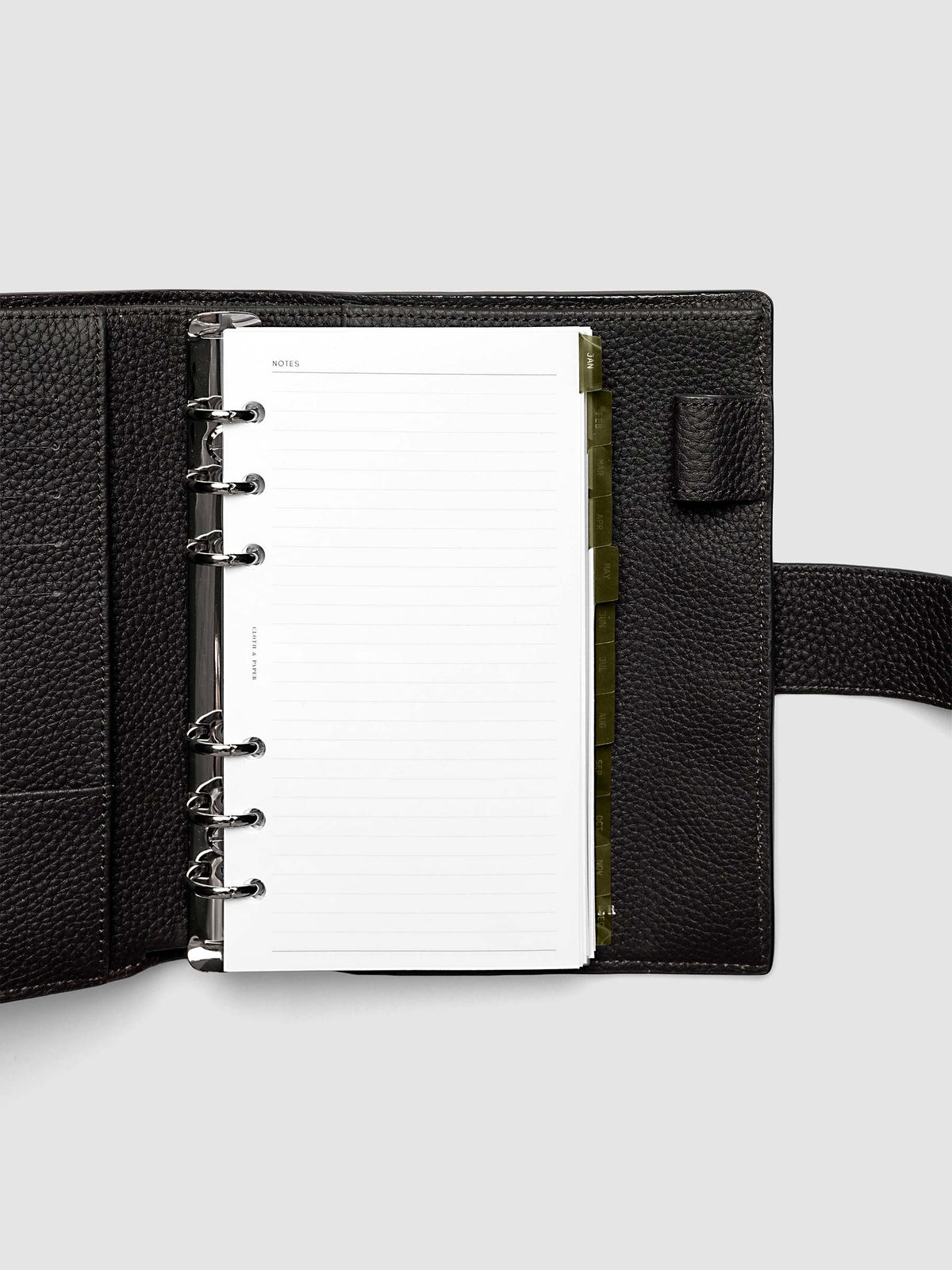 Personal 6-Ring Punch Ultra-Thin Monthly Dividers in olive green shown tabbed inside a planner