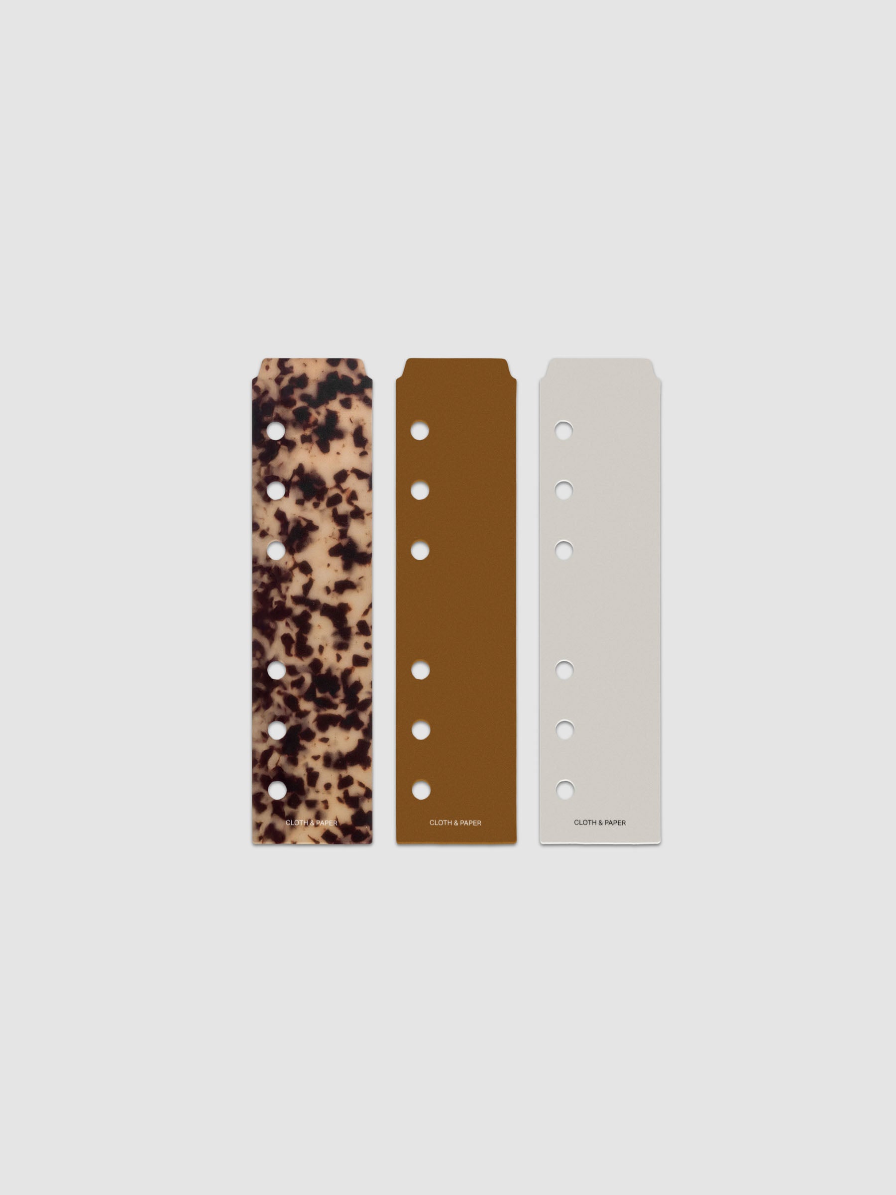 Narrow Page Marker Set Vol. 2, a set of 3 page markers for planners and notebooks shown in size A6. Includes one tortoiseshell pattern, one solid brown, and one solid grey page marker.