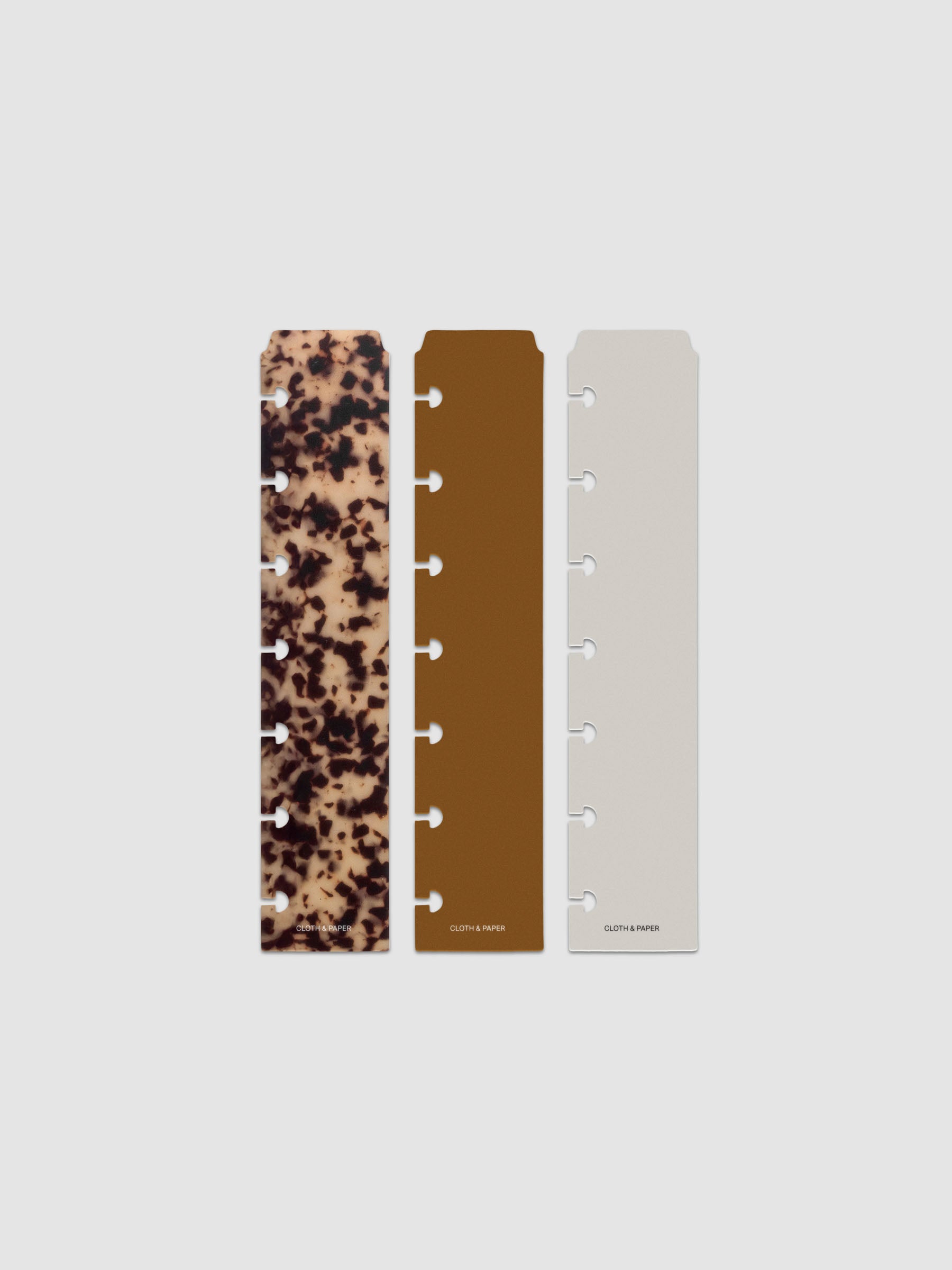 Narrow Page Marker Set Vol. 2, a set of 3 page markers for planners and notebooks shown in size HP Mini. Includes one tortoiseshell pattern, one solid brown, and one solid grey page marker.