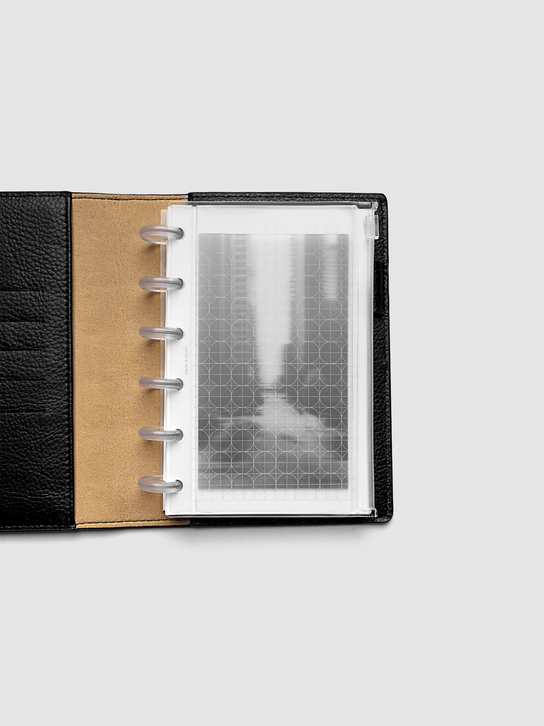 Side zipper transparent storage pouch for planners with decorative inner graph and photograph layers shown in a CP Petite planner folio cover.
