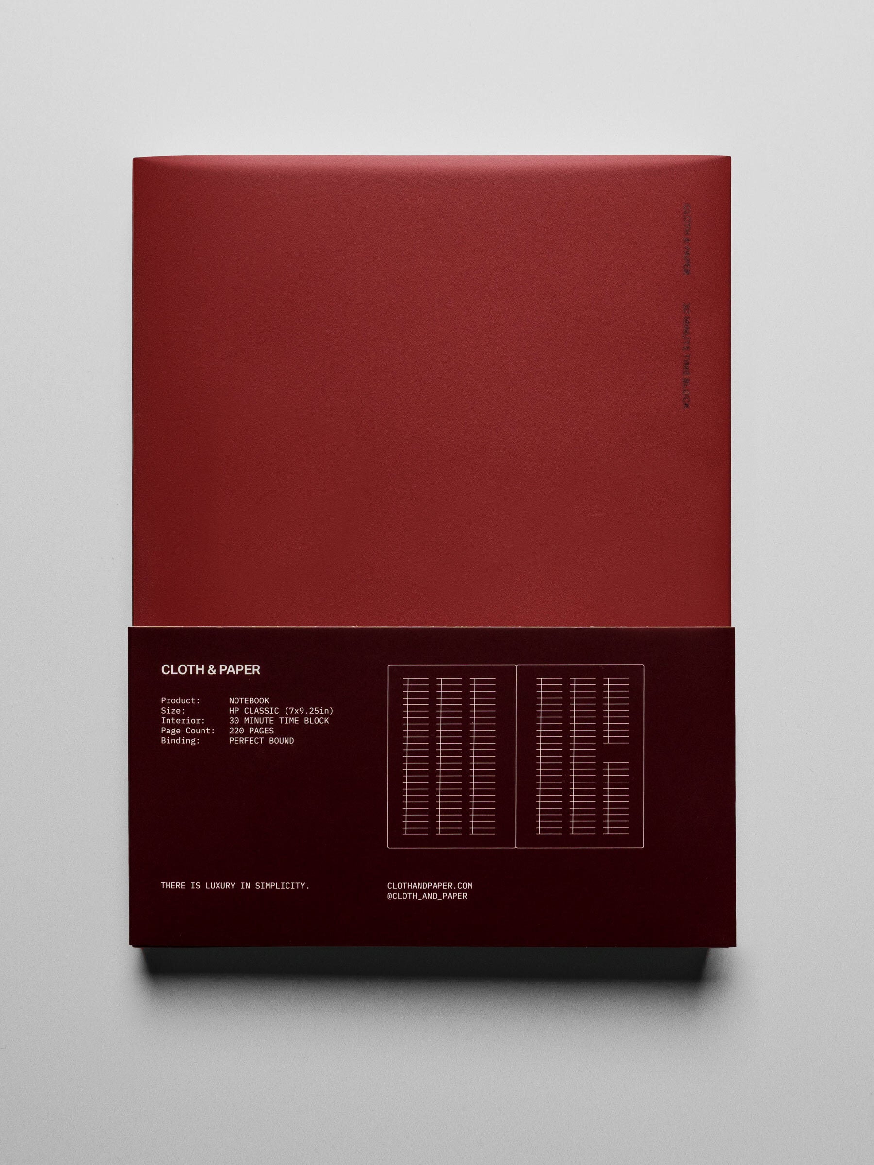 Perfect Bound Notebook in size HP Classic with 30 Minute Time Block pages and a red cover shown closed from the front with packaging belly band.