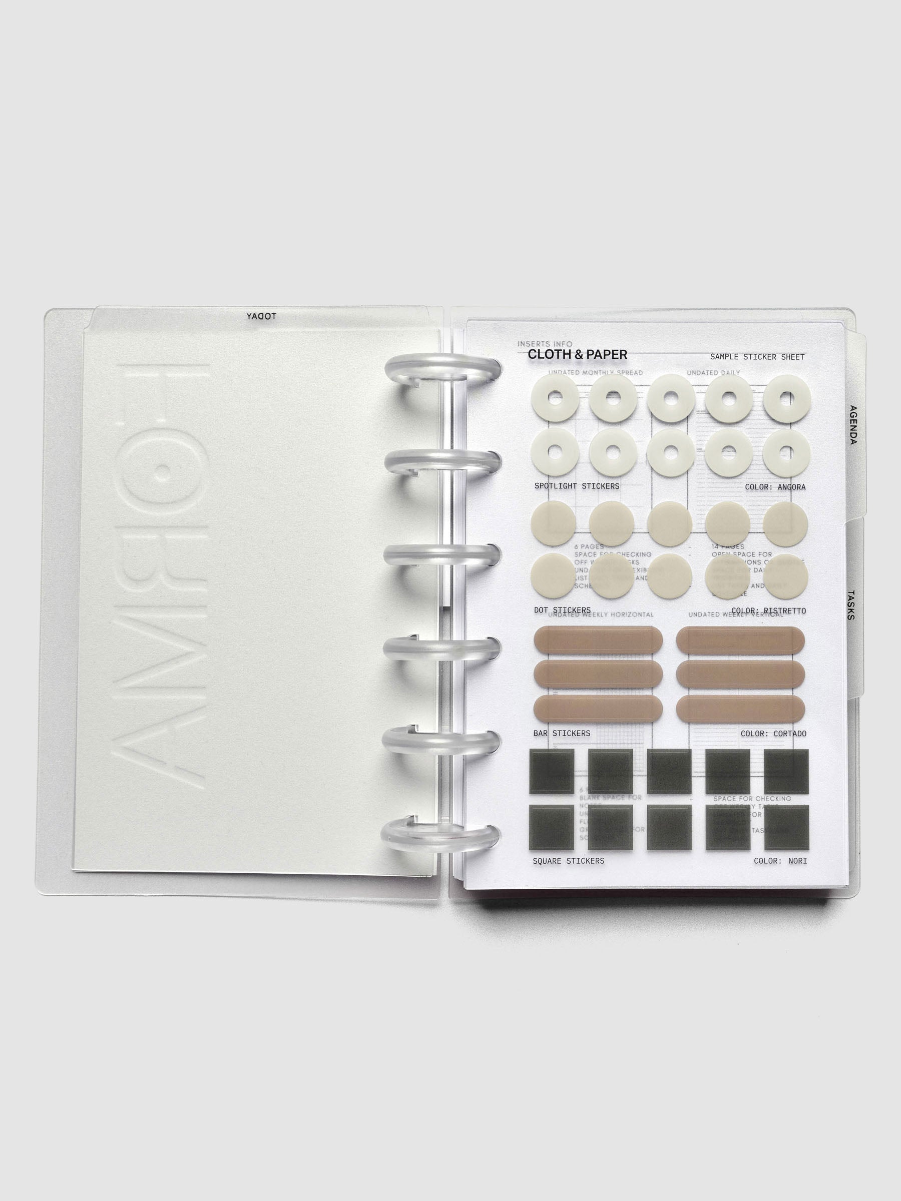 Open discbound planner displaying sticker sheet with four shapes and colors of stickers.