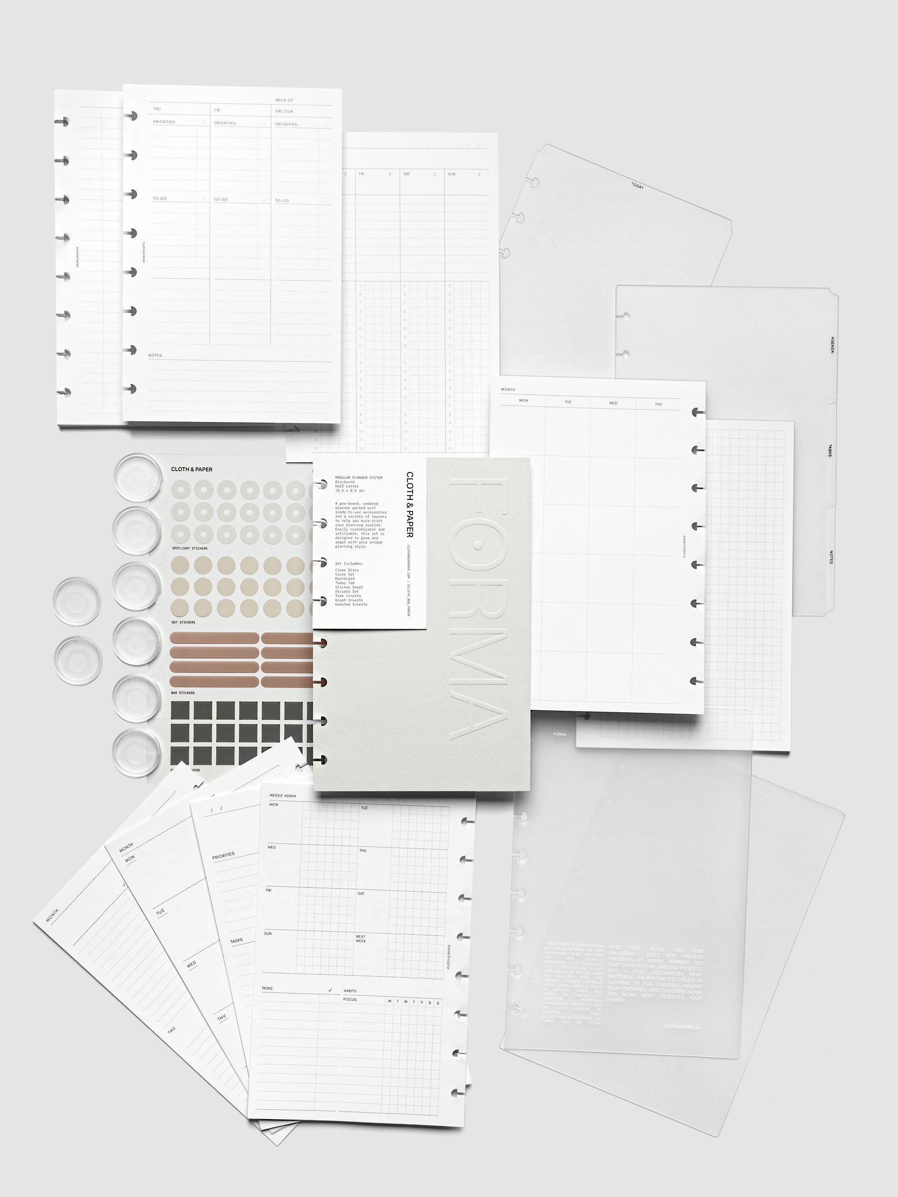 All items in the Forma Modular Planner System in Half Letter laid out on a neutral background. Includes covers, dashboards, tabbed dividers, planner discs, planner inserts, and a sticker sheet.