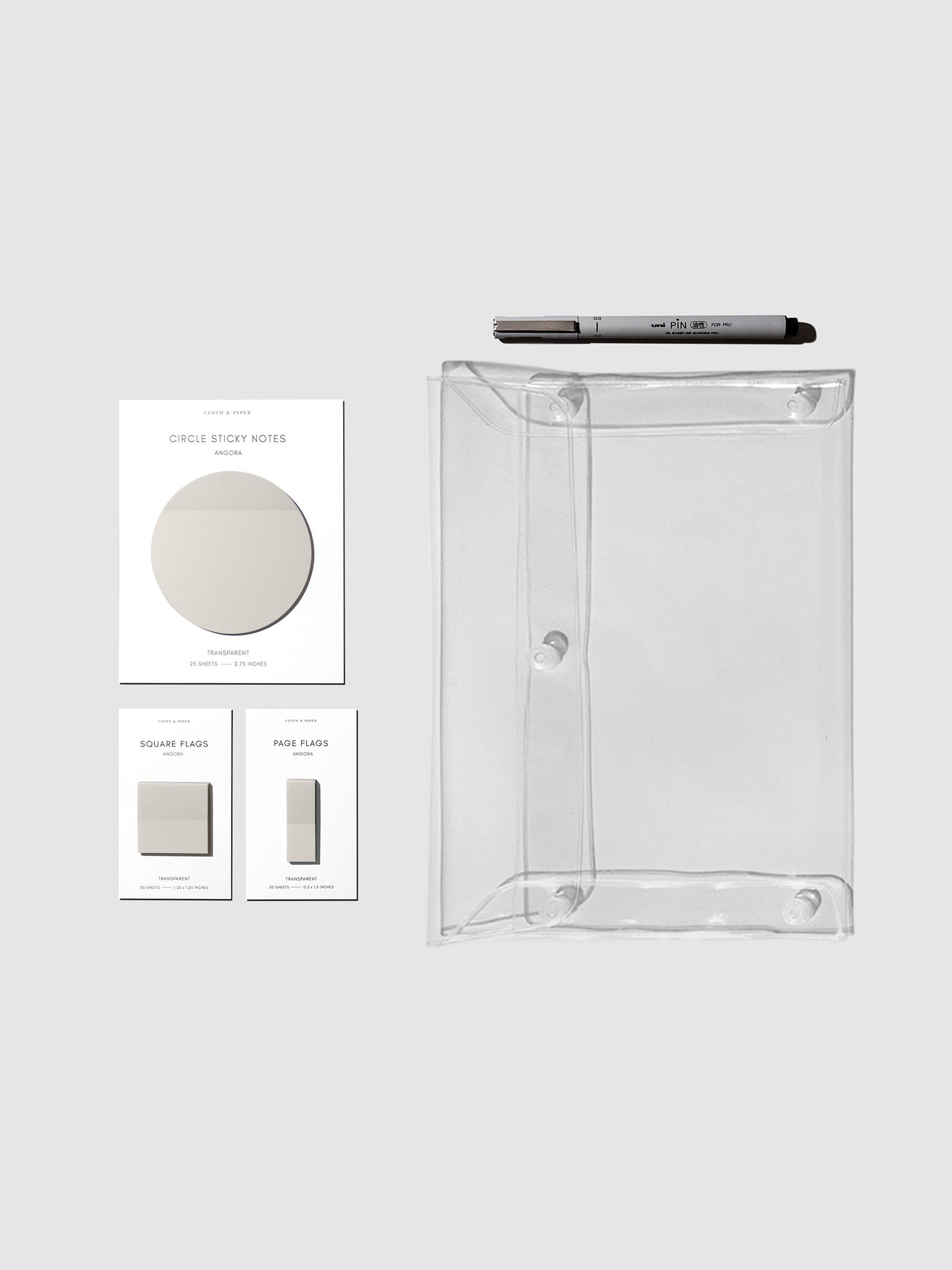 Color Bundle, Angora, Cloth & Paper. Matching set of circle sticky notes, page flags, and square page flags positioned next to a Uni Pin Marking Pen and Essentials Clear pouch. Sticky note color is Angora.