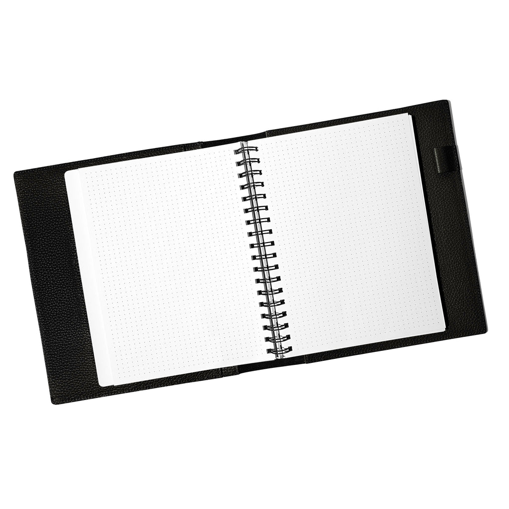 Notebook spread open inside a black leather agenda. Design shown is dot grid.