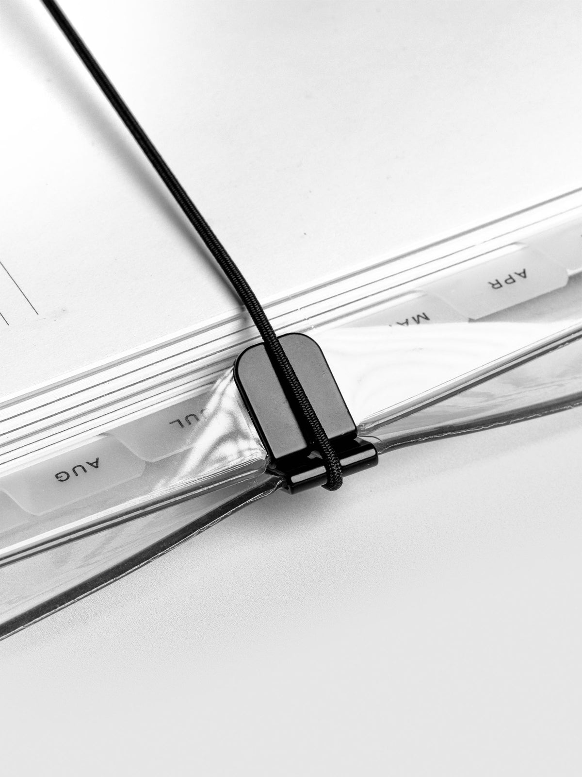 Close up of the bungee cord closure on the clear vinyl planner cover.