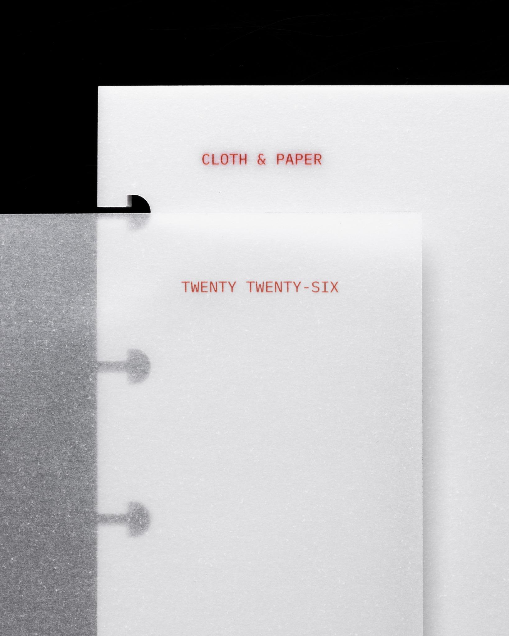 Layered vellum dashboards with red Cloth & Paper branding and 'Twenty Twenty-Six' printed on translucent inserts.