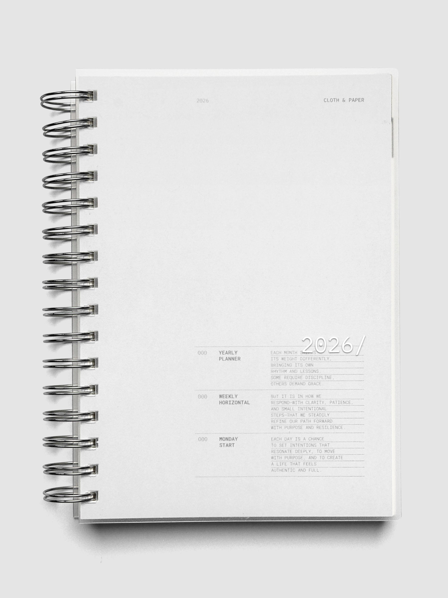 A5 size, silver spiral bound 2026 planner shown closed laying flat on a neutral background.