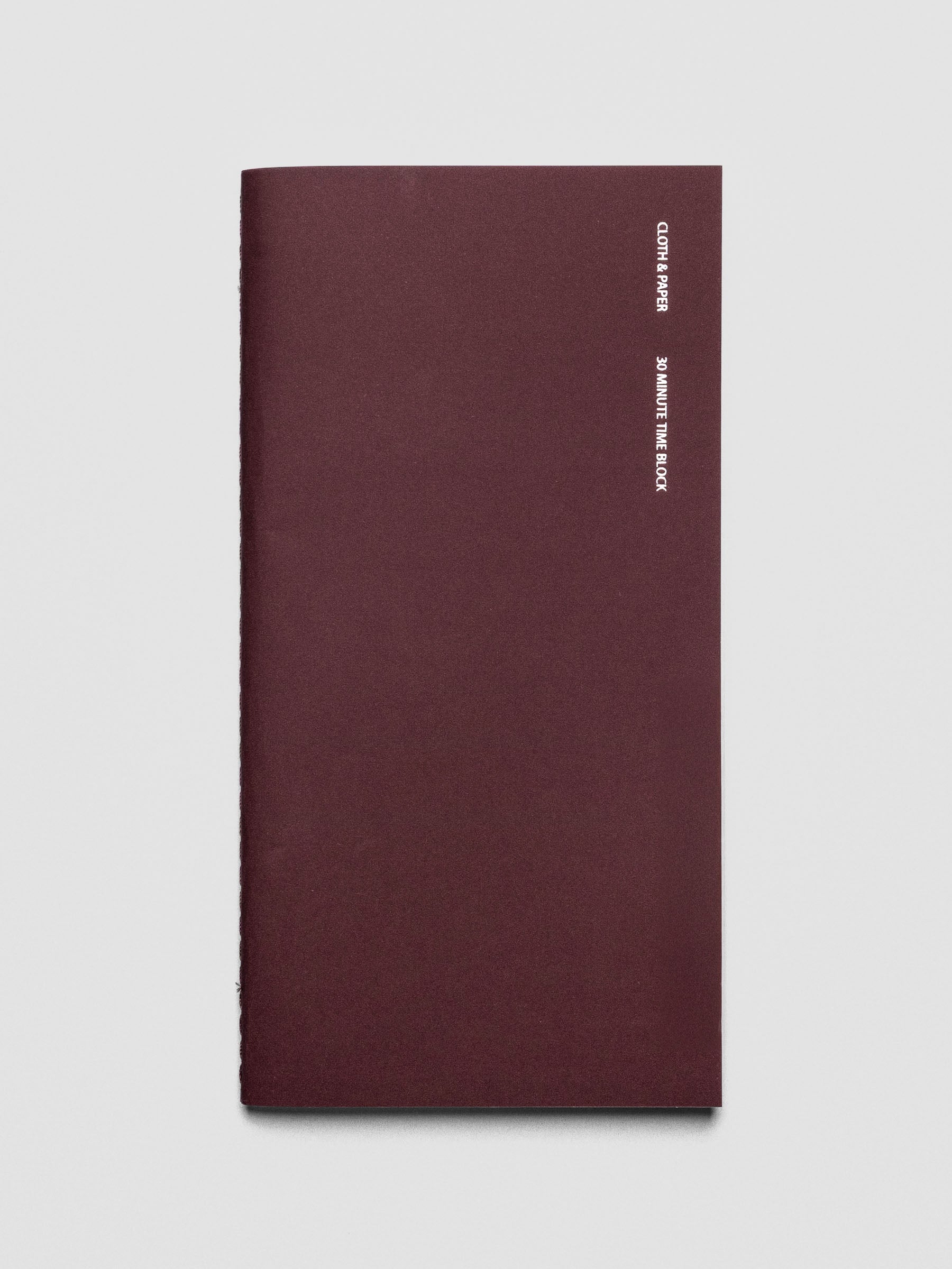 Travel Notebook in size A5 Slim in color Bordeux with 30 Minute Time Block pages shown from the front.