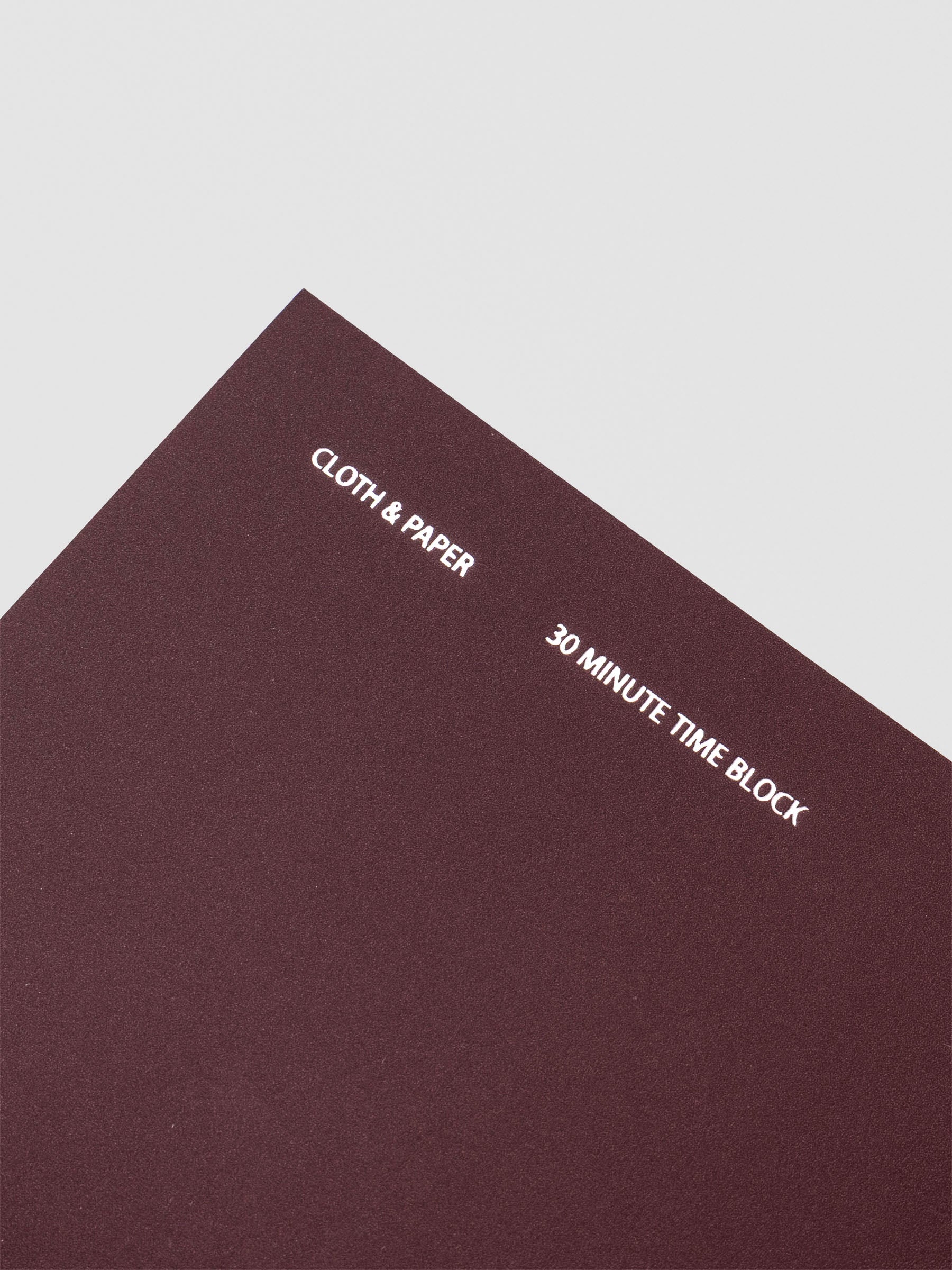 Travel Notebook in size A5 Slim in color Bordeux with 30 Minute Time Block pages shown from the front as a close up.