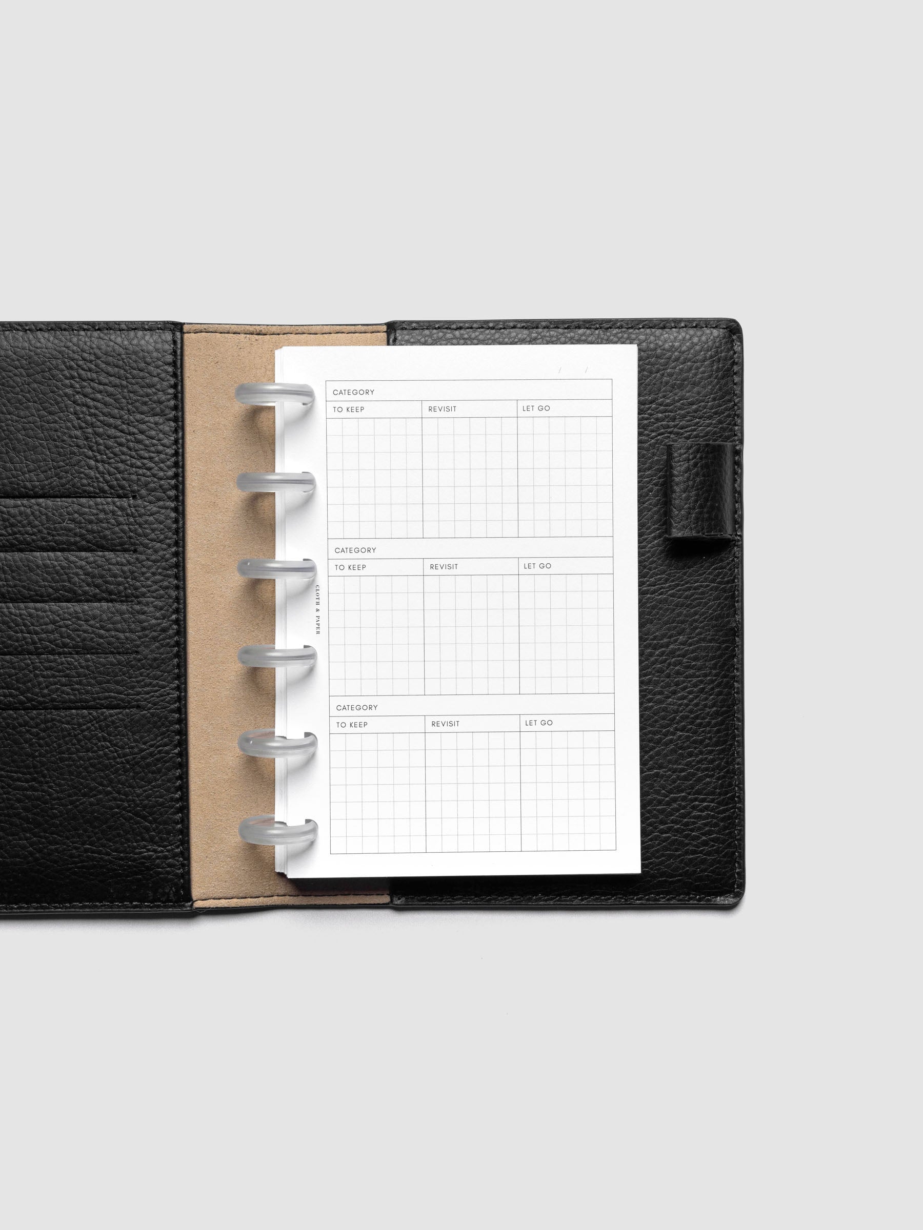 Declutter Planner Inserts in size CP Petite shown discbound in a black leather folio.