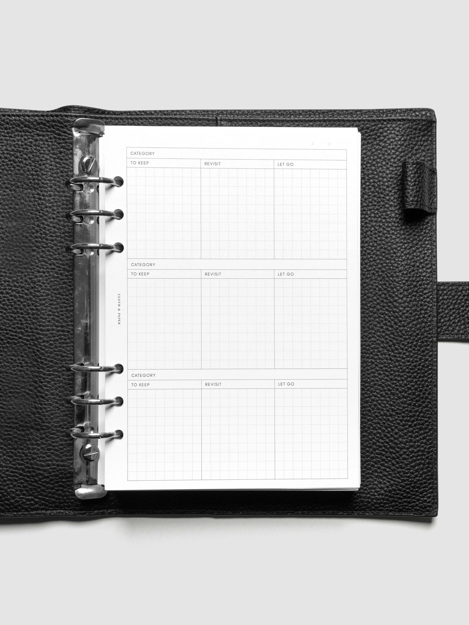 Declutter Planner Inserts in size A5 shown ring bound in a black leather agenda.