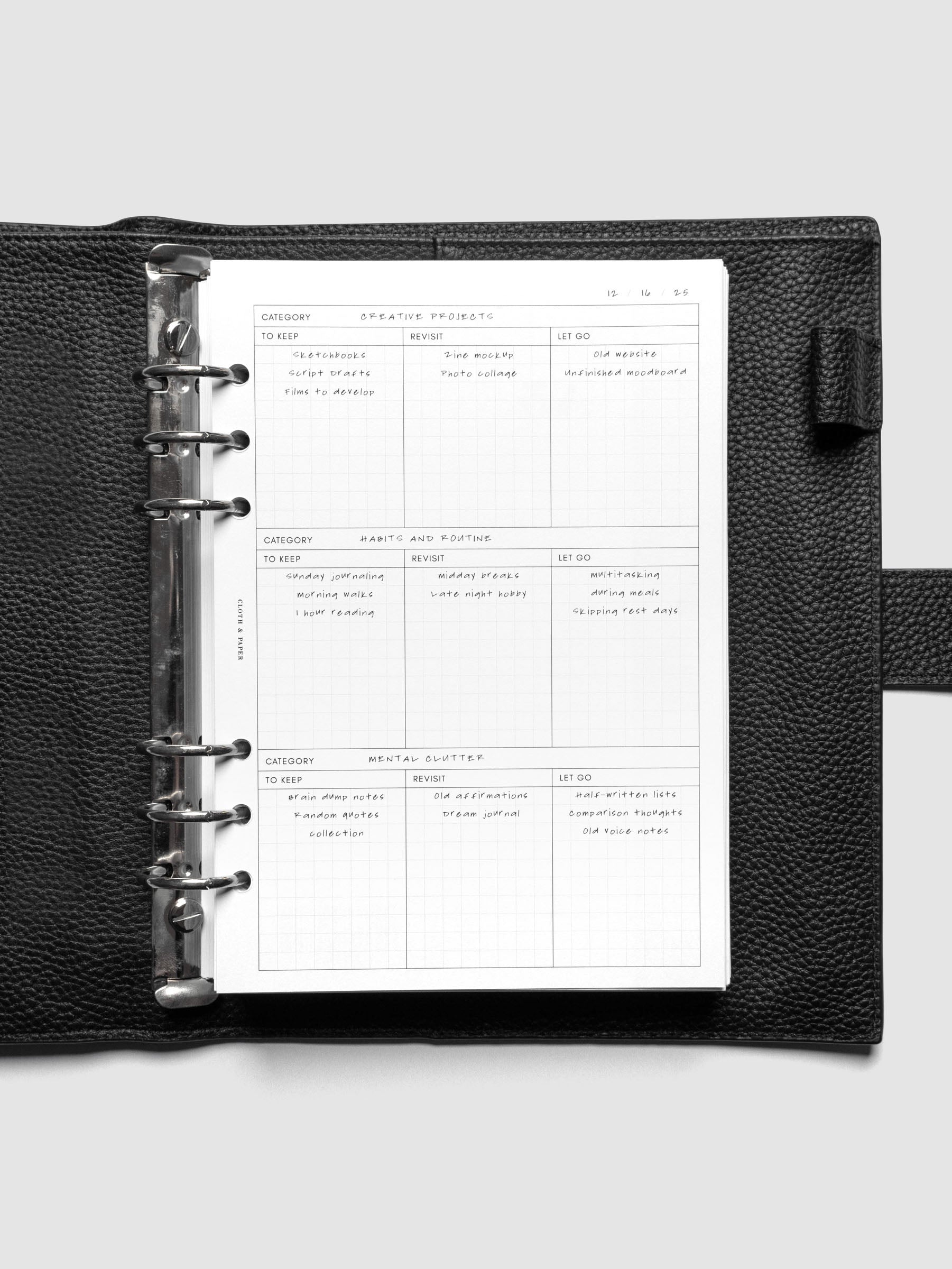 Declutter Planner Inserts with handwritten notes in size A5 shown ring bound in a black leather agenda.
