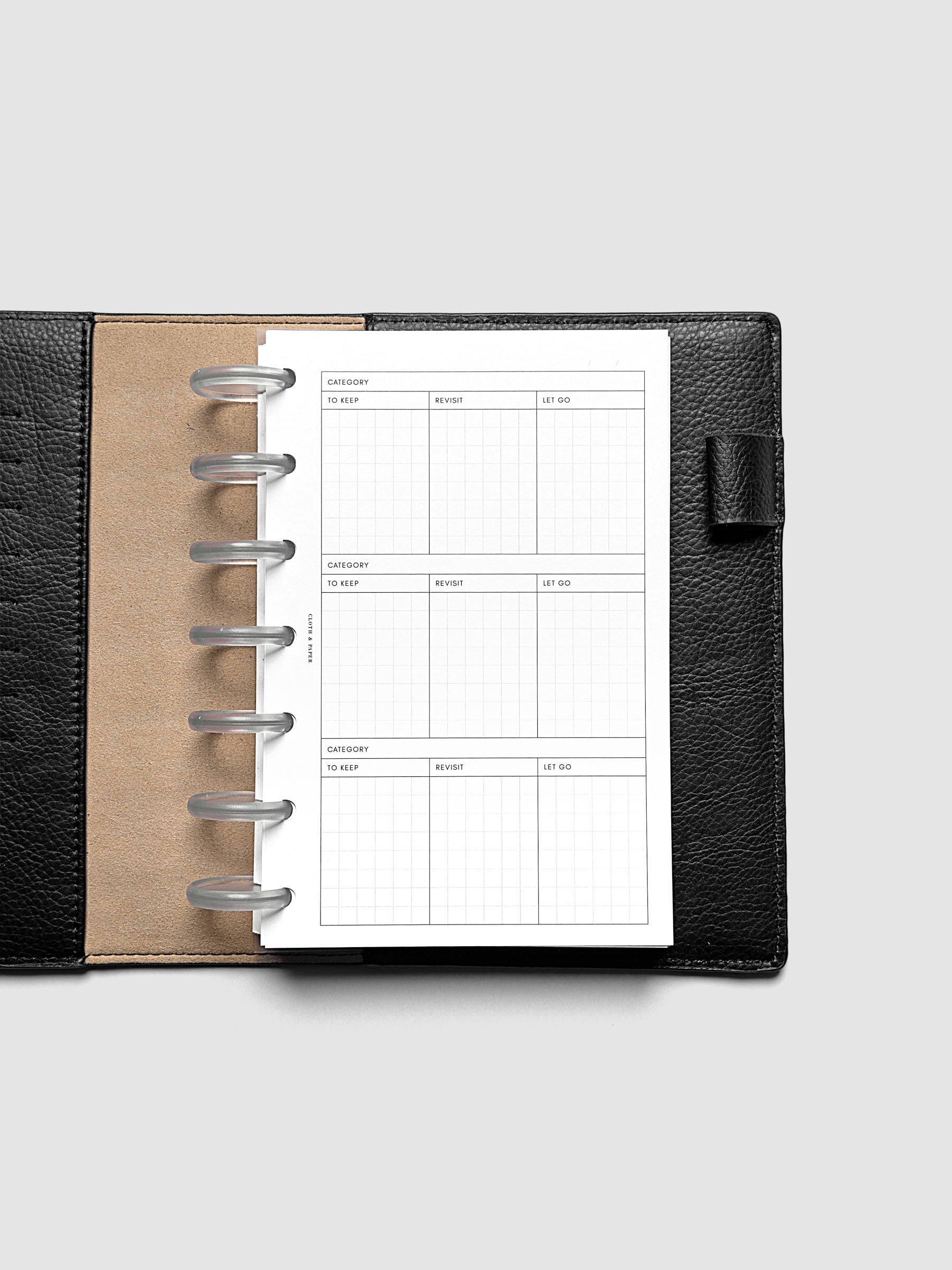 Declutter Planner Inserts in size HP Mini shown discbound in a black leather folio.
