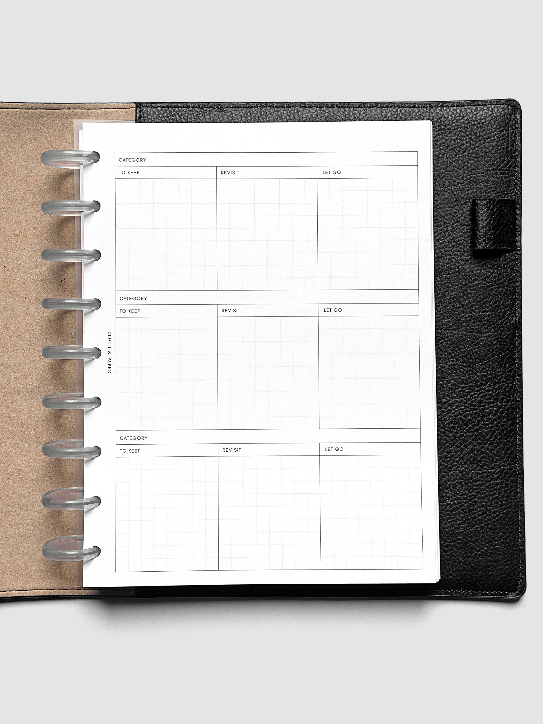 Declutter Planner Inserts in size HP Classic shown discbound in a black leather folio.