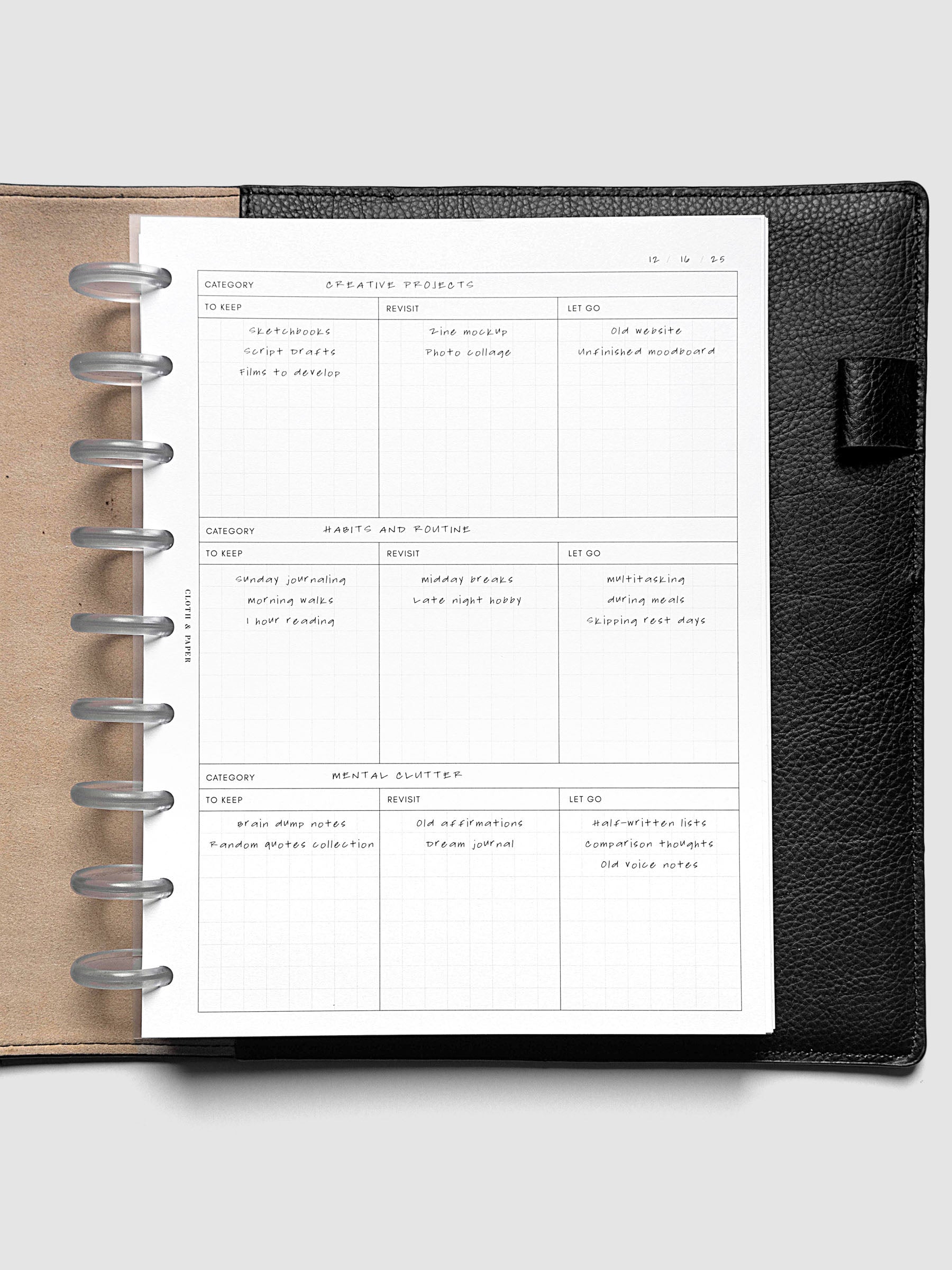 Declutter Planner Inserts with handwritten notes in size HP Classic shown discbound in a black leather folio.
