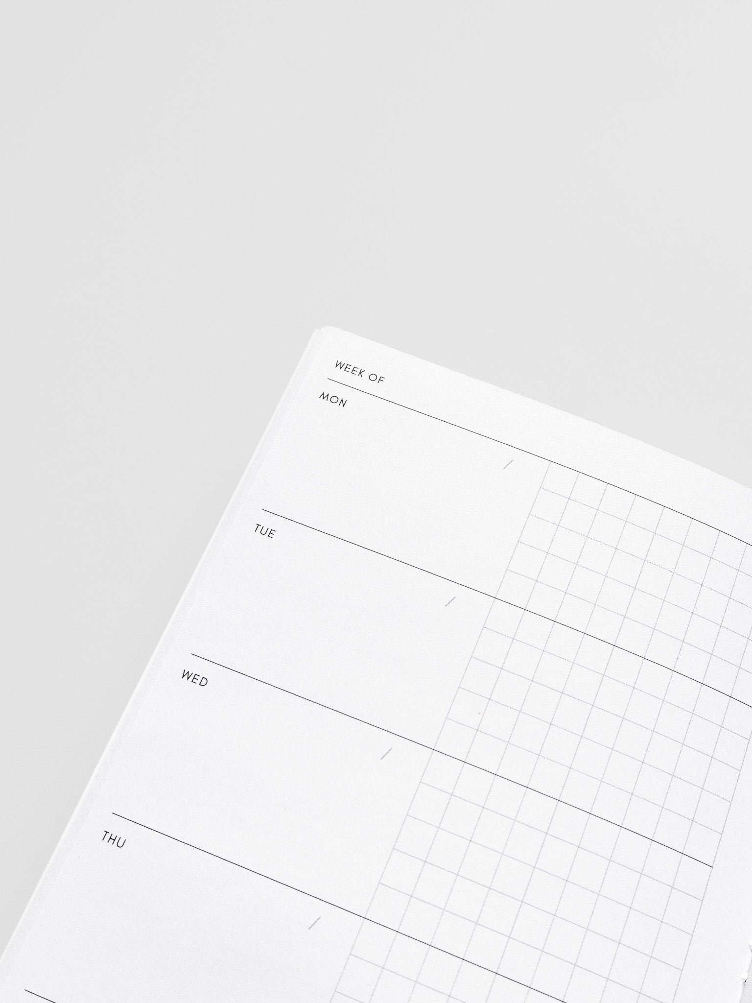 Interior of Travel Notebook in size A5 Slim displaying a horizontal weekly layout with a monday start in two columns with blank and graph.