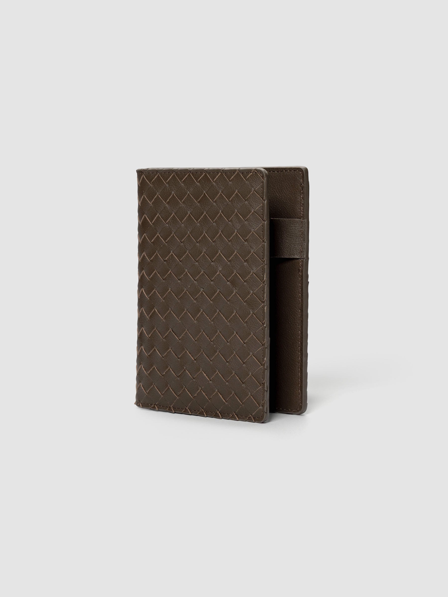 Dark brown woven leather planner cover shown standing at an angle.