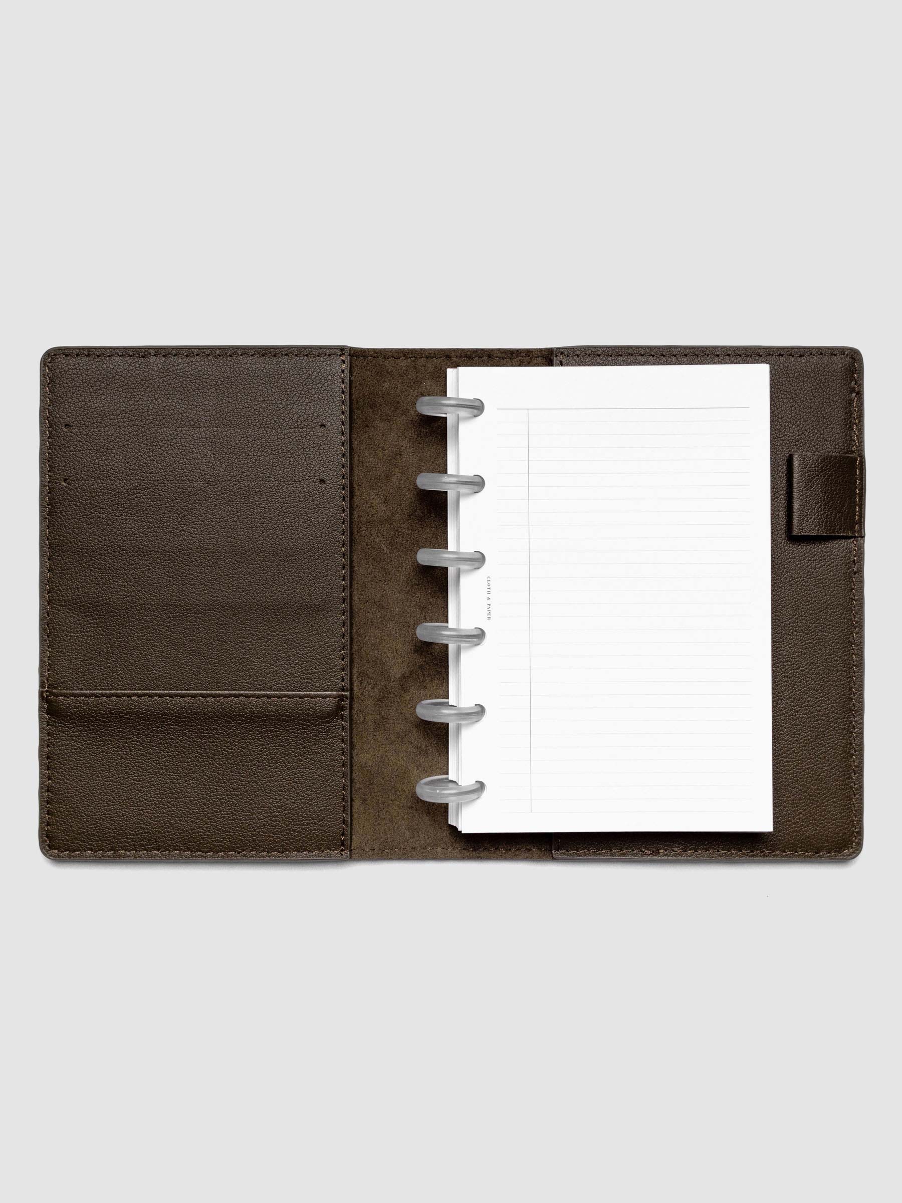 Open dark brown leather planner folio with a CP petite discbound planner inside.
