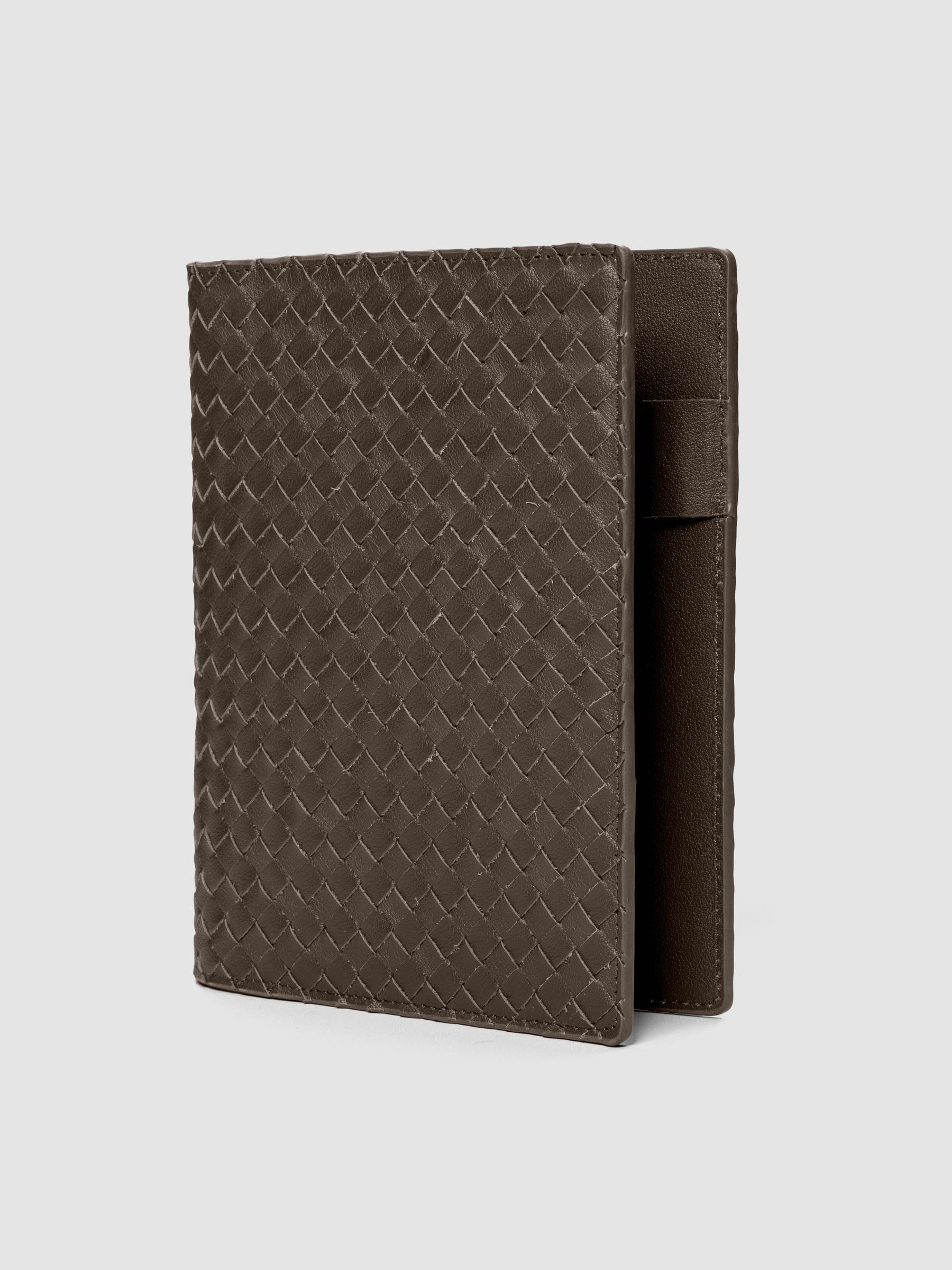 Dark brown woven leather planner cover shown standing at an angle.