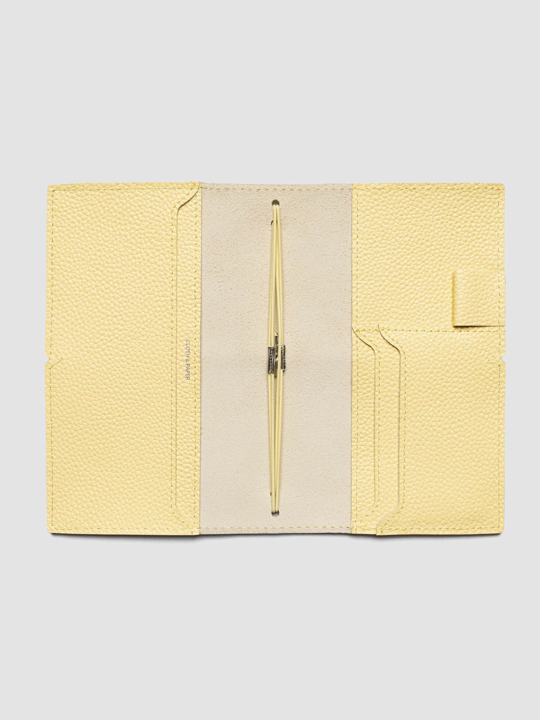 Butter yellow leather travel notebook cover in size Pocket Plus shown open with interior pockes and elastic bands.