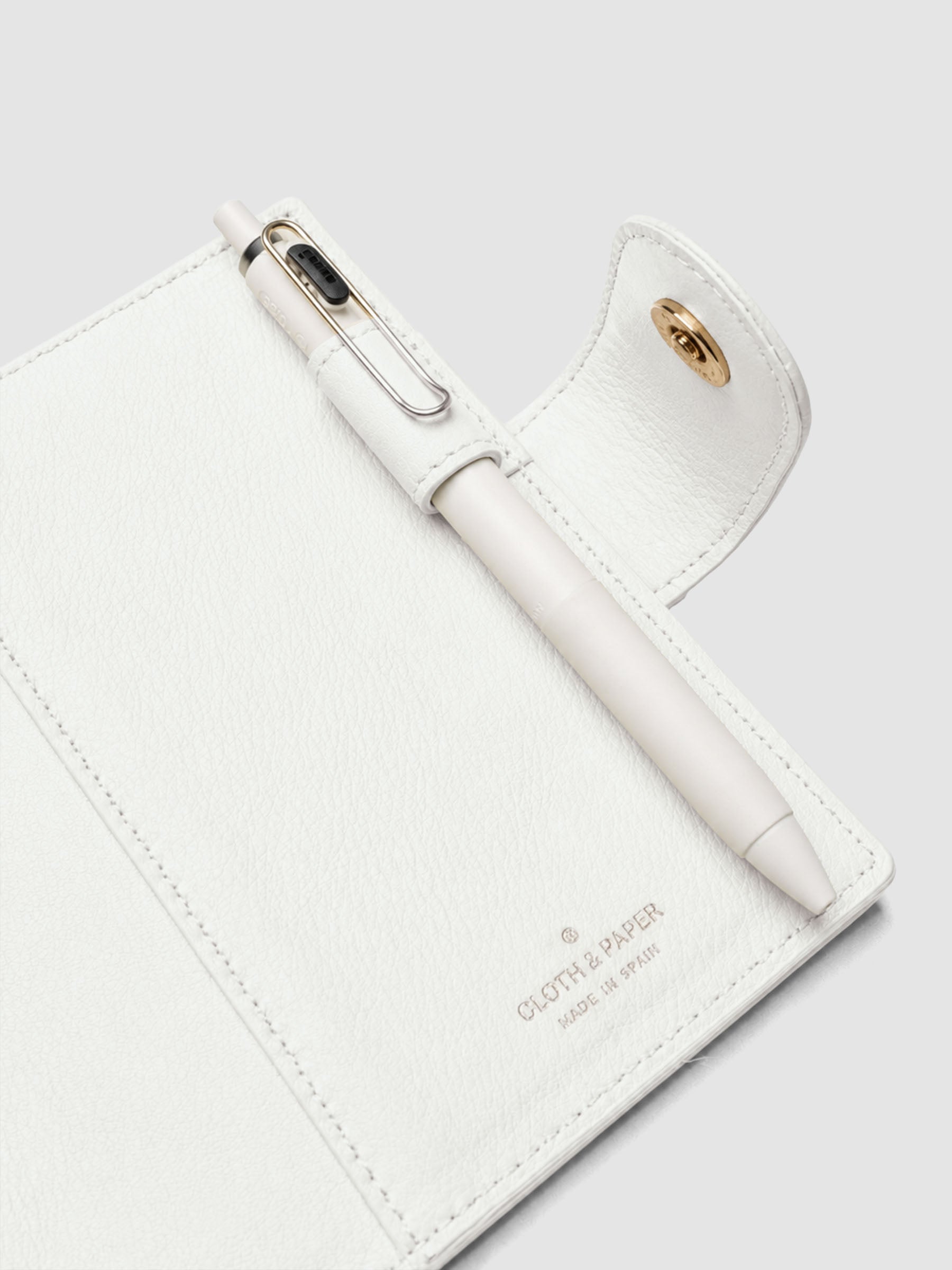 Heirloom Ring Cover Genuine Leather Pocket 6-Ring Punch in off-white, detail view of interior pen loop, large pocket, and closure with pen in pen loop