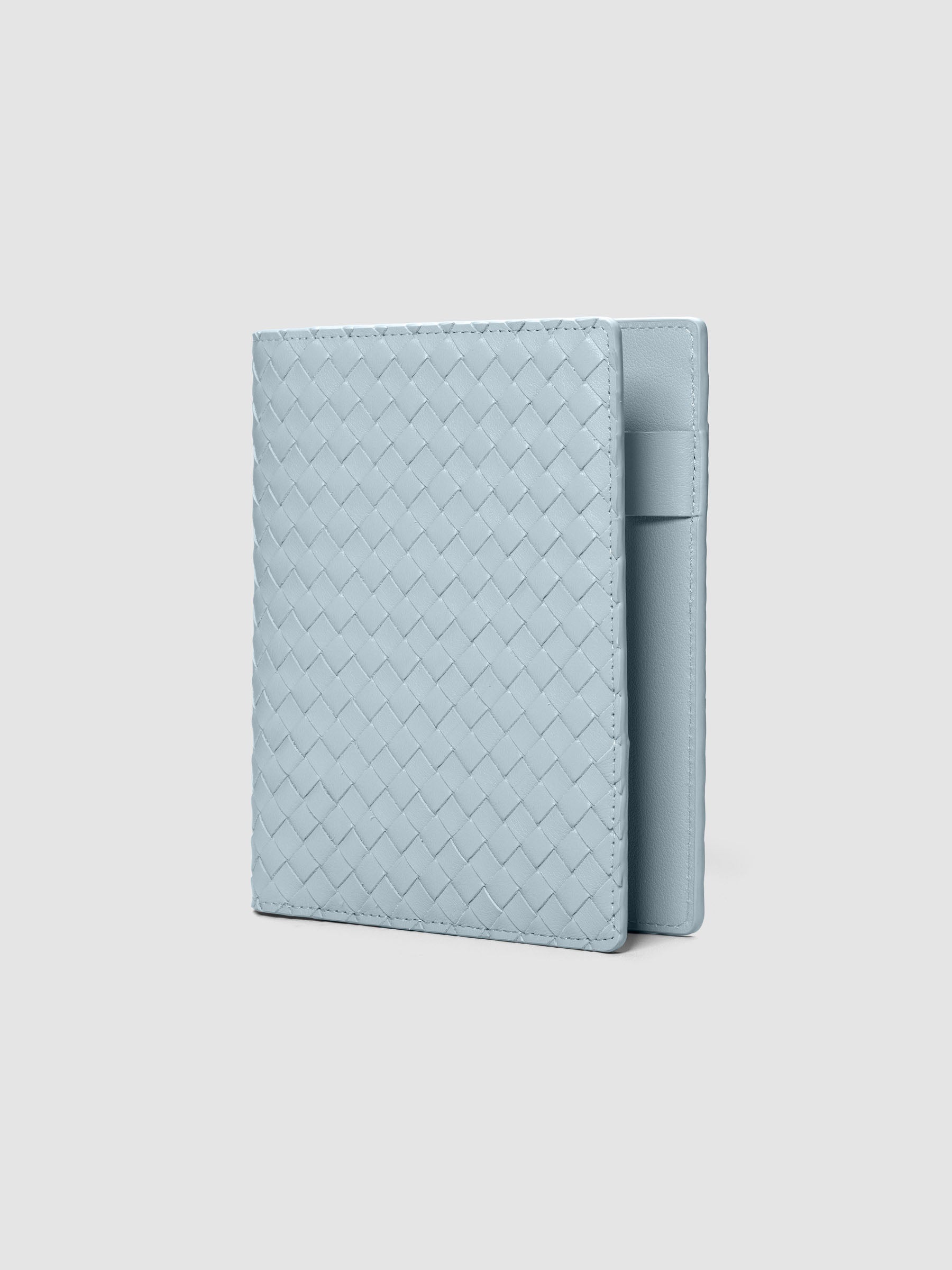 Blue woven leather planner cover shown standing at an angle.