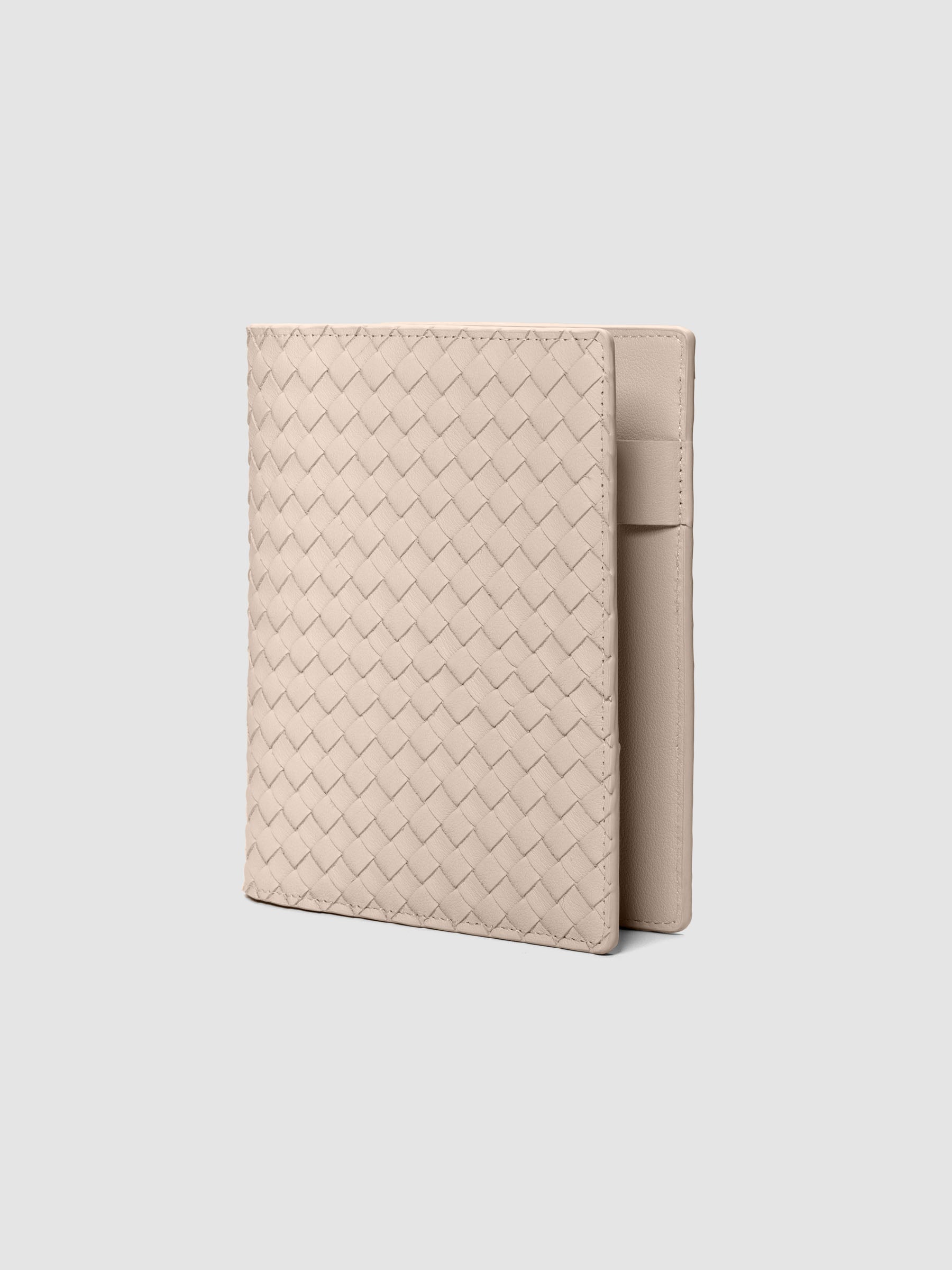 Beige woven leather planner cover shown standing at an angle.