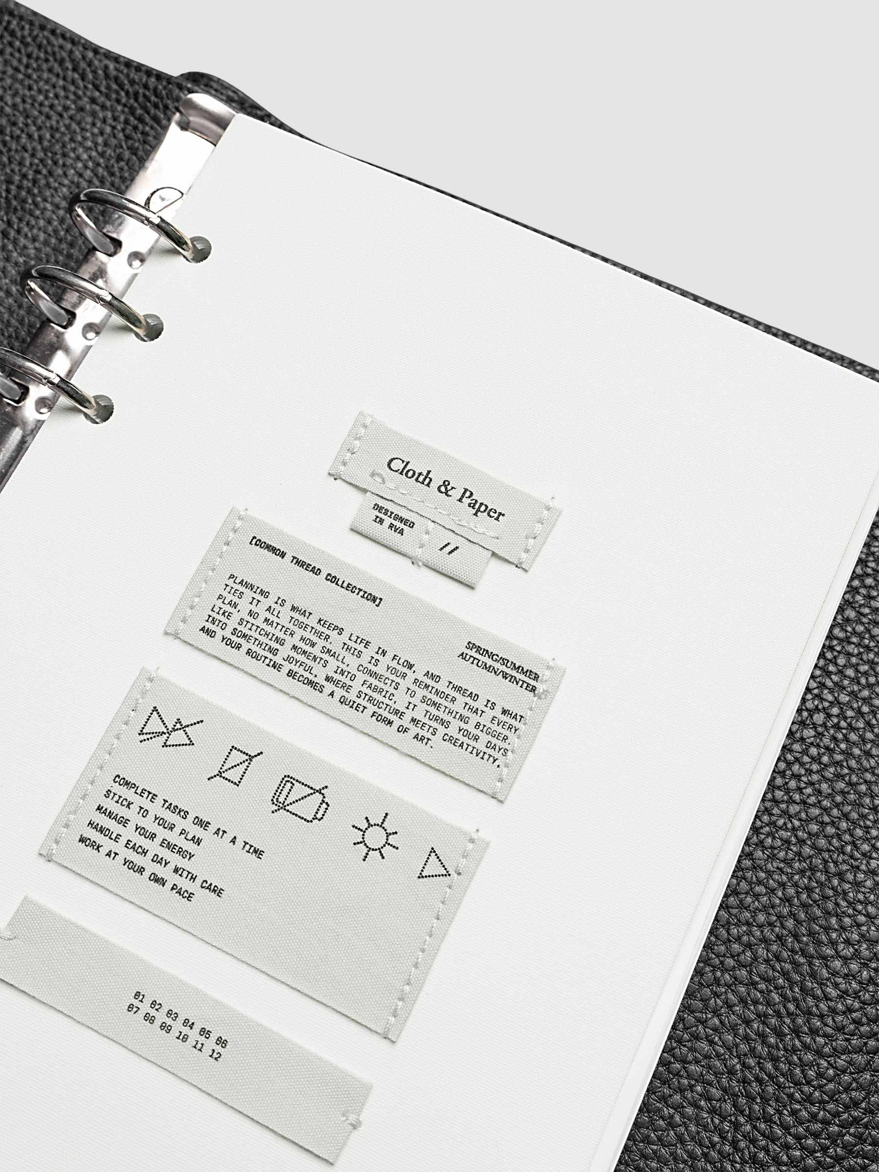 Sewn Tags Planner Dashboard pre-punched for 6-ring planners in size A5 shown in a black leather agenda.