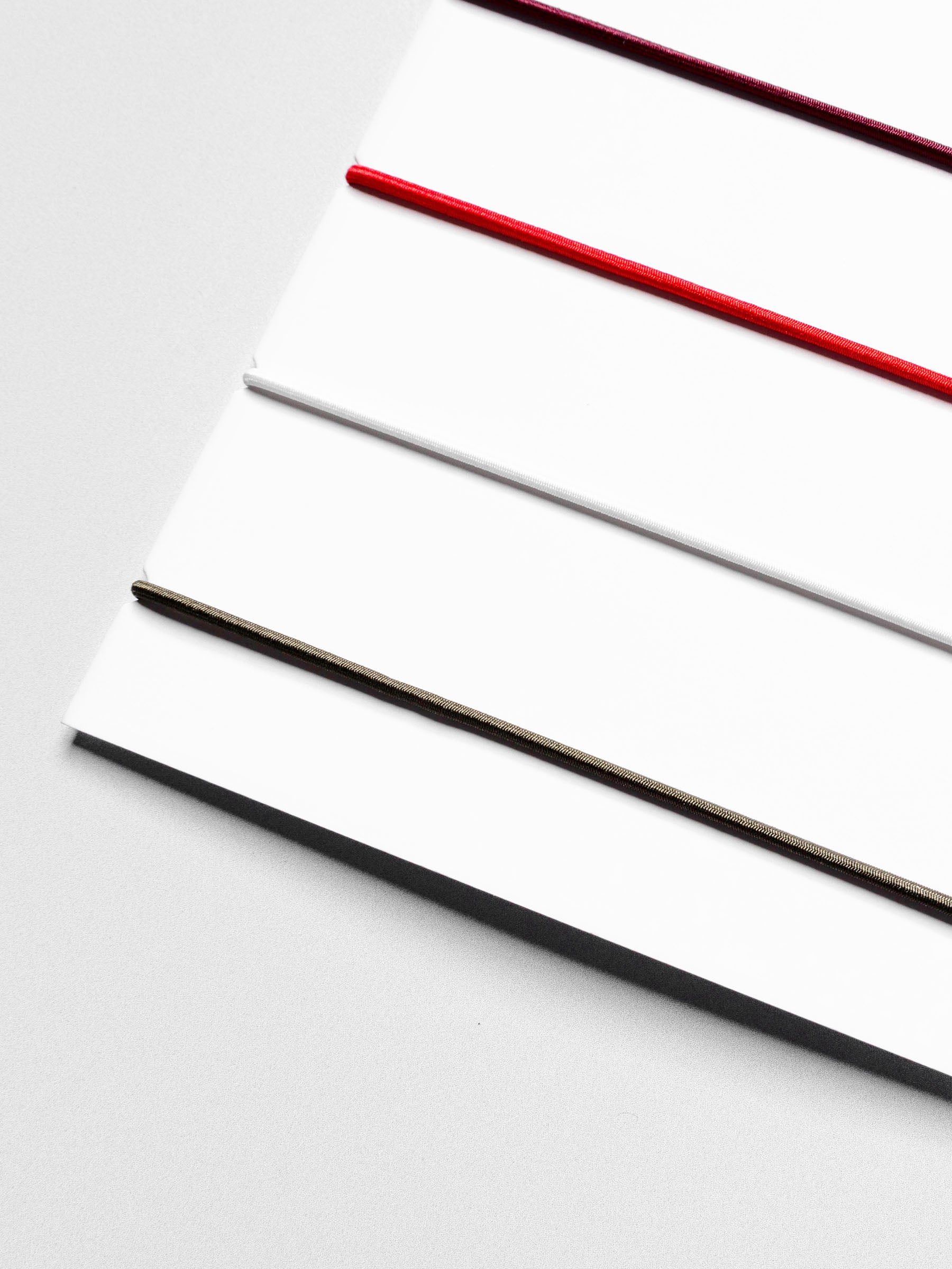 Closeup of travel bands displayed in their packaging on a neutral background.