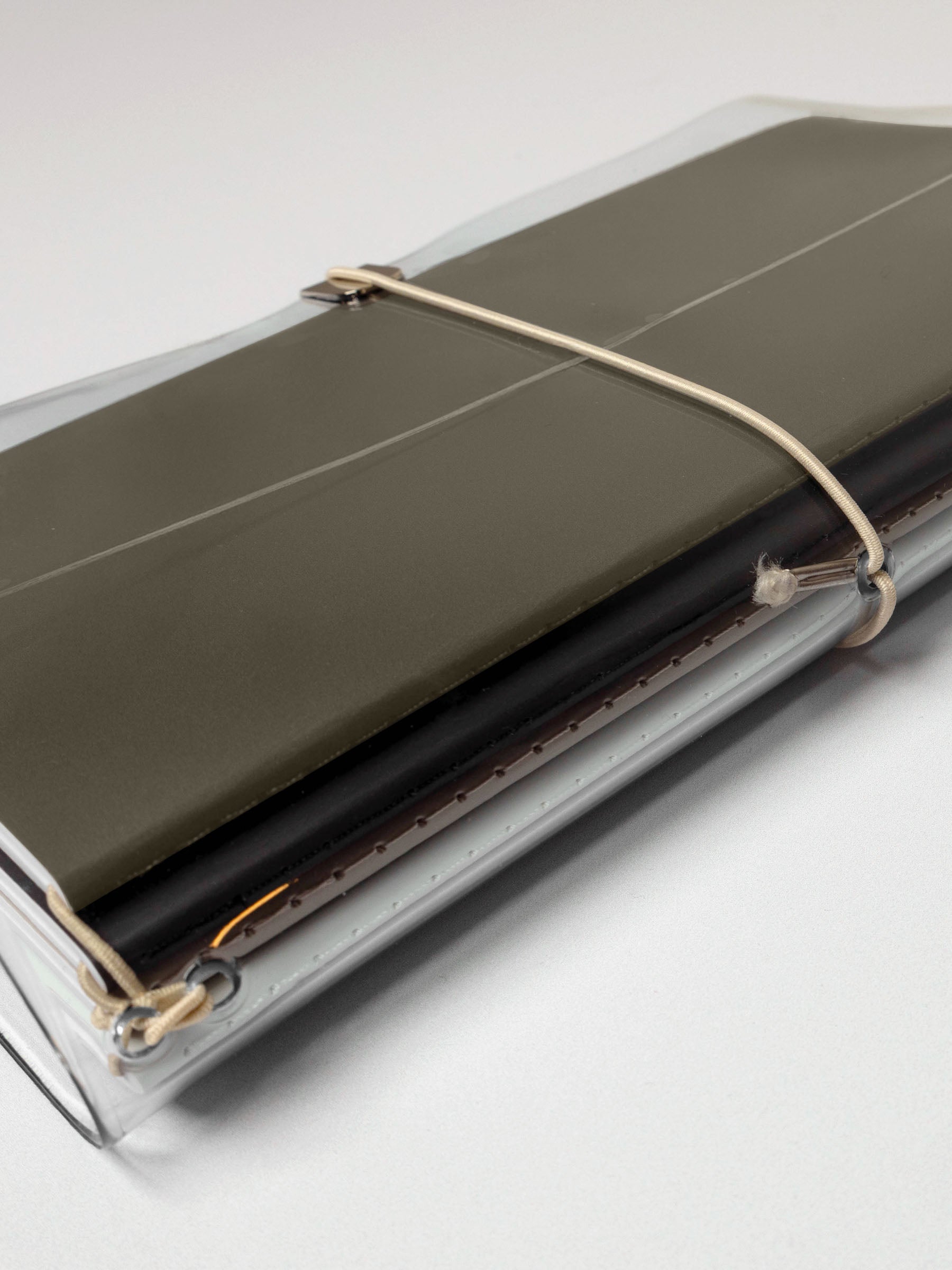 Side-view of the clear vinyl planner with a set of travel notebooks attached