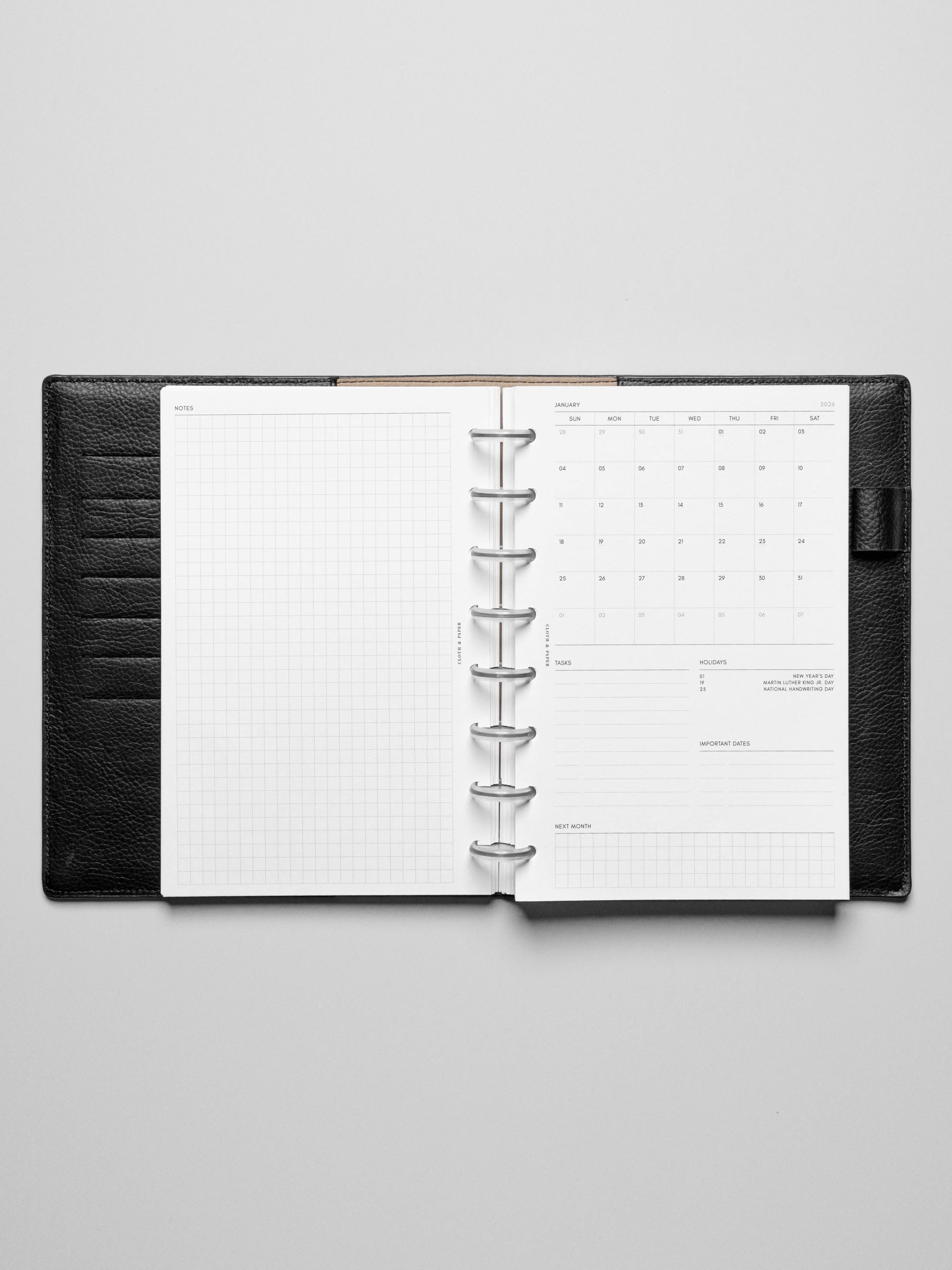 Image shows the Sunday Start 2026 Dated Monthly Admin Planner Inserts in a black leather disc-bound planner.