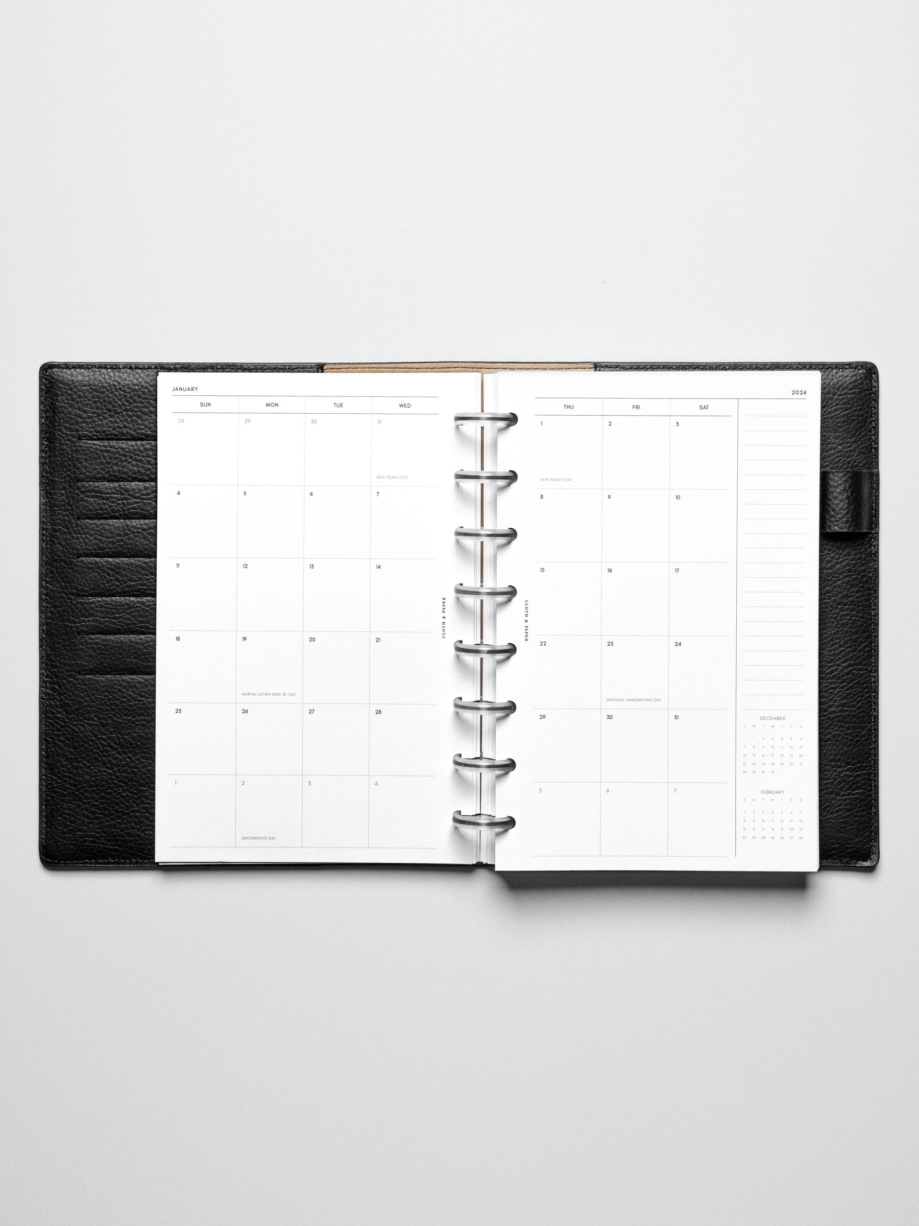 Image shows the Sunday Start 2026 Dated Monthly Planner Inserts in a black leather disc-bound planner.
