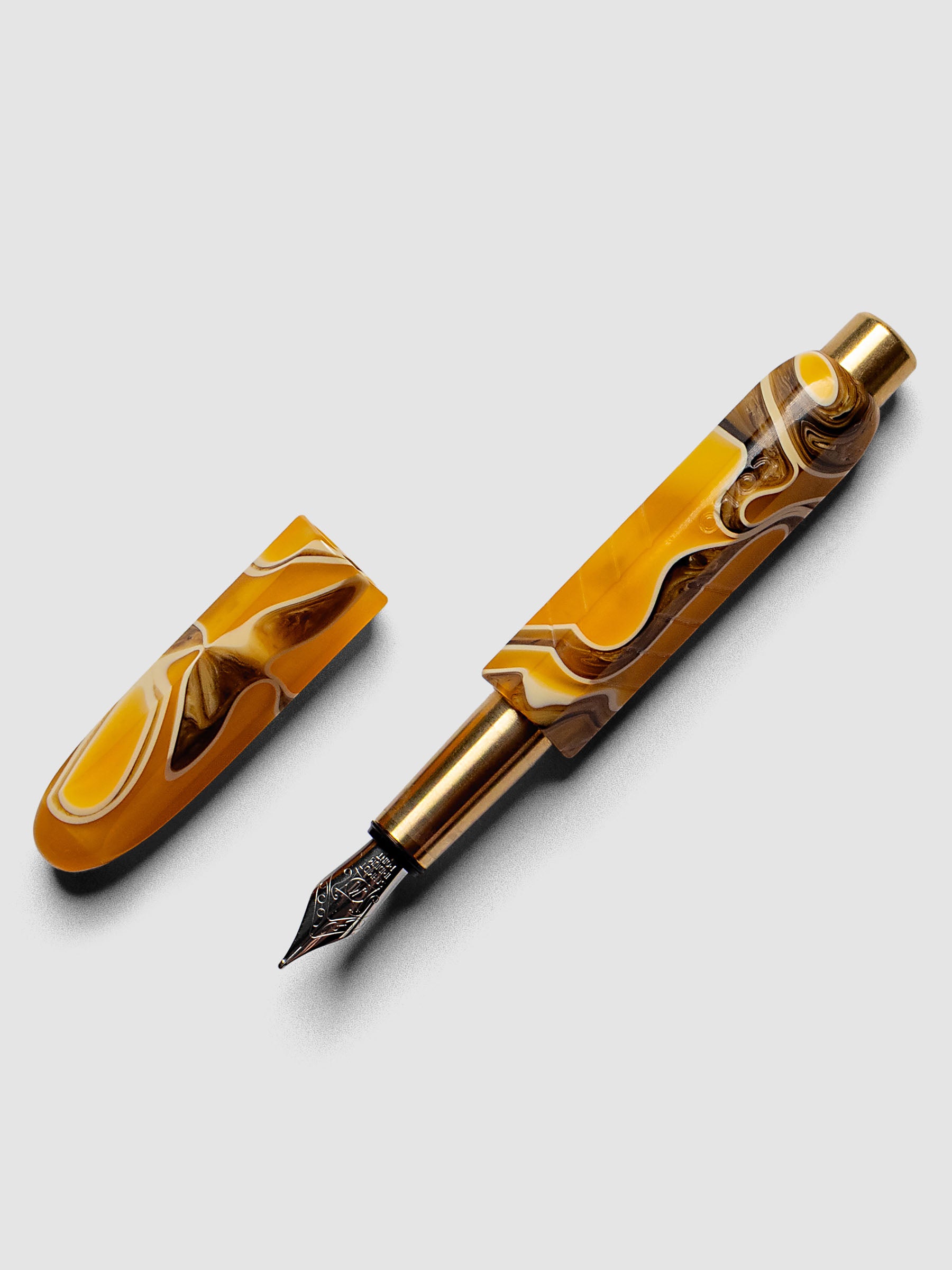 Kolo Tino Fountain Pen in the color Dune, a variegated yellow, brown, and beige barrel with brass accents and a silver medium nib shown with cap off.