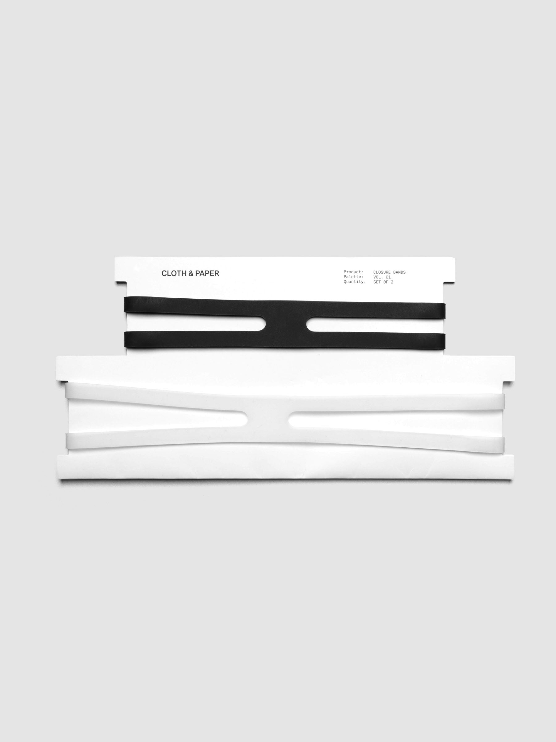 Two planner closure bands, one black and one clear, shown on white packaging.