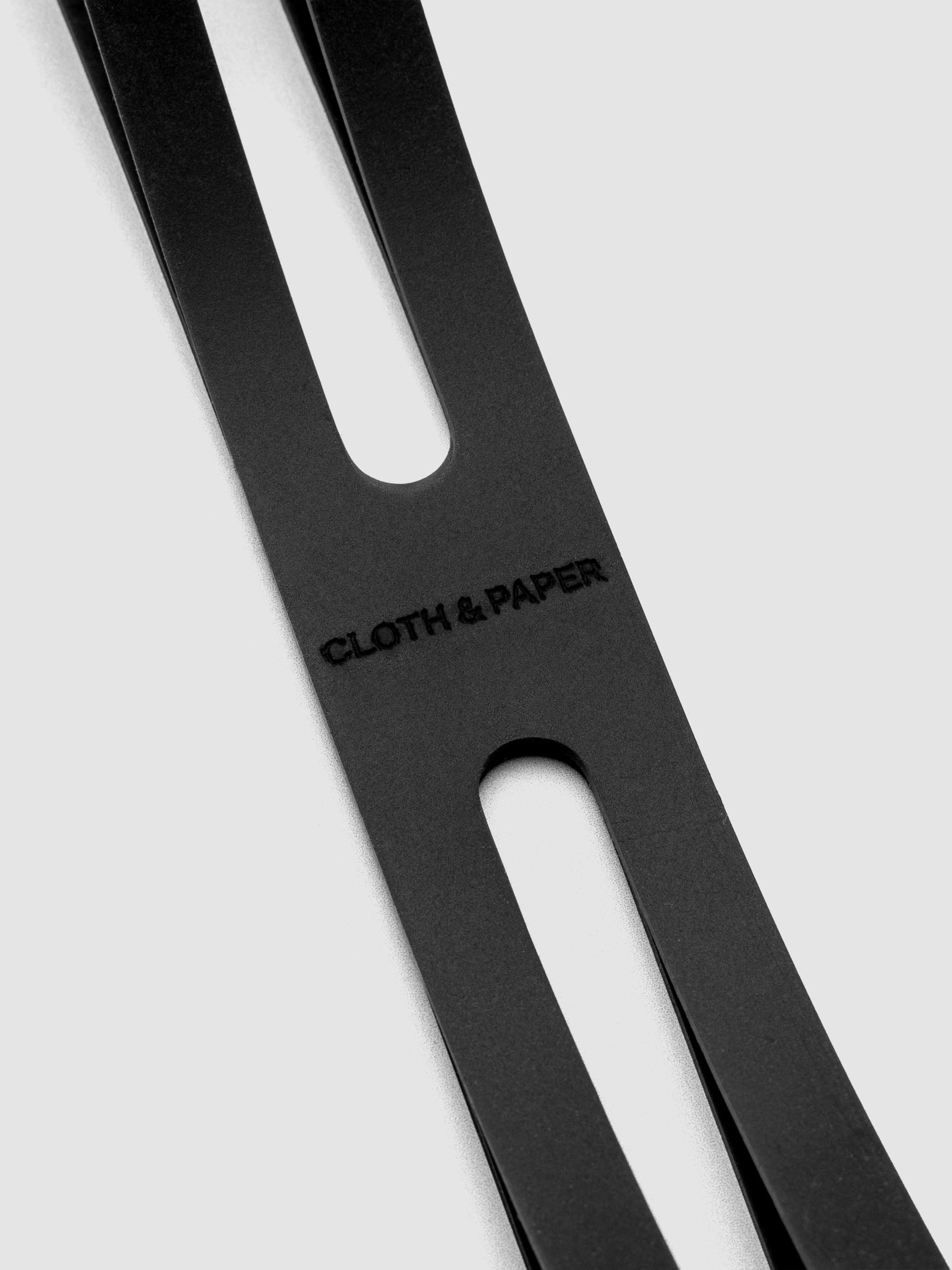 Detail view of Cloth & Paper logo on black planner closure band.