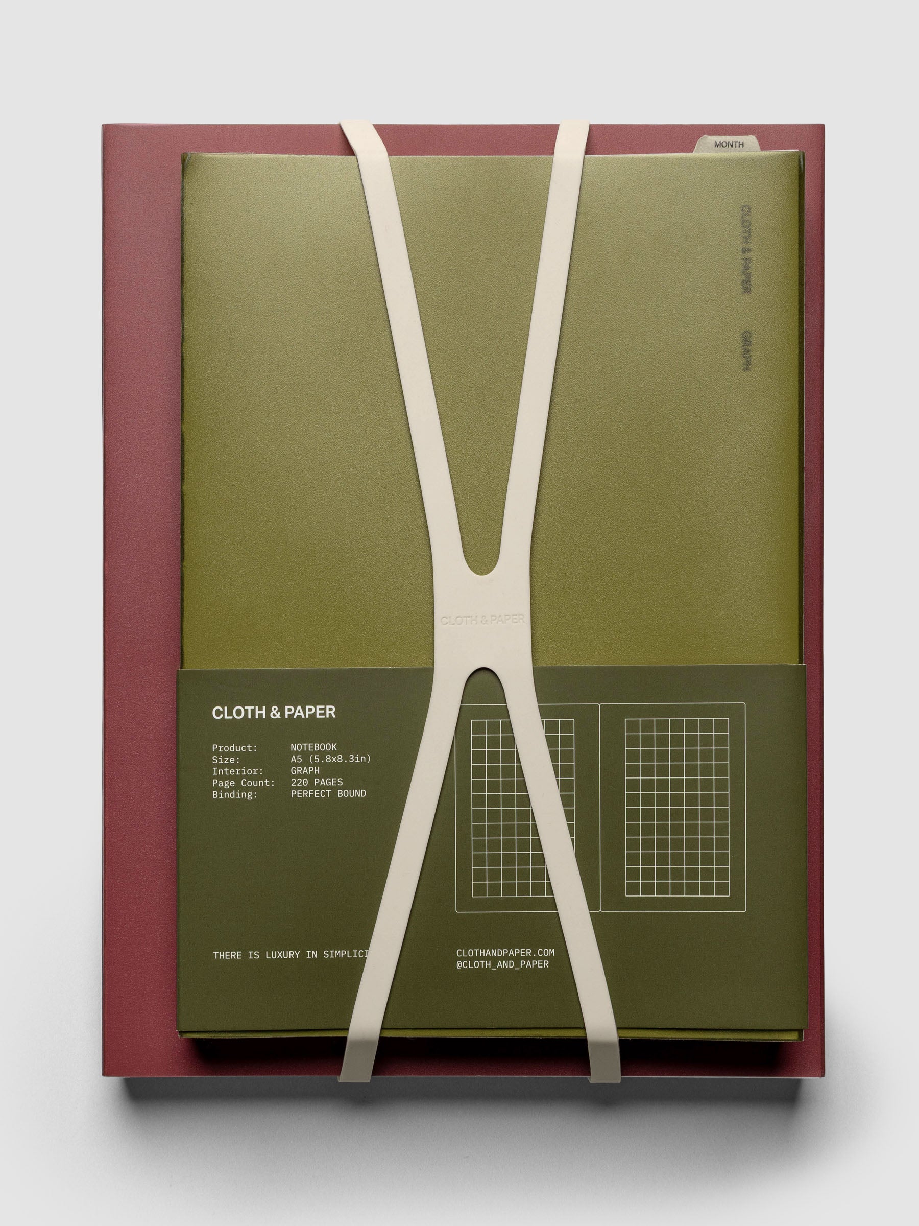 Large, beige planner closure band shown holding an A5 perfect bound notebook on top of an HP Classic perfect bound notebook.