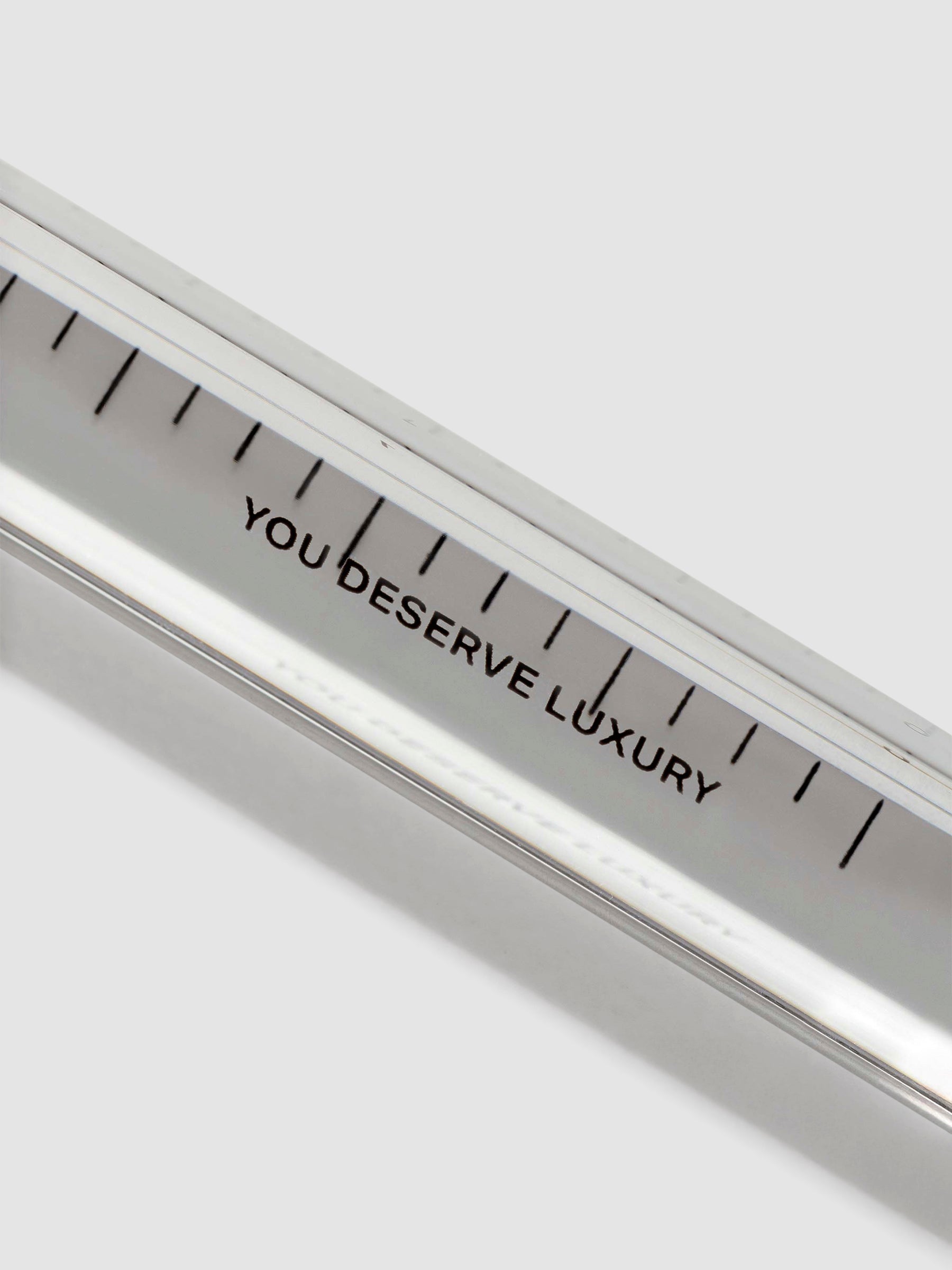 Close up of text on ruler that reads "YOU DESERVE LUXURY."
