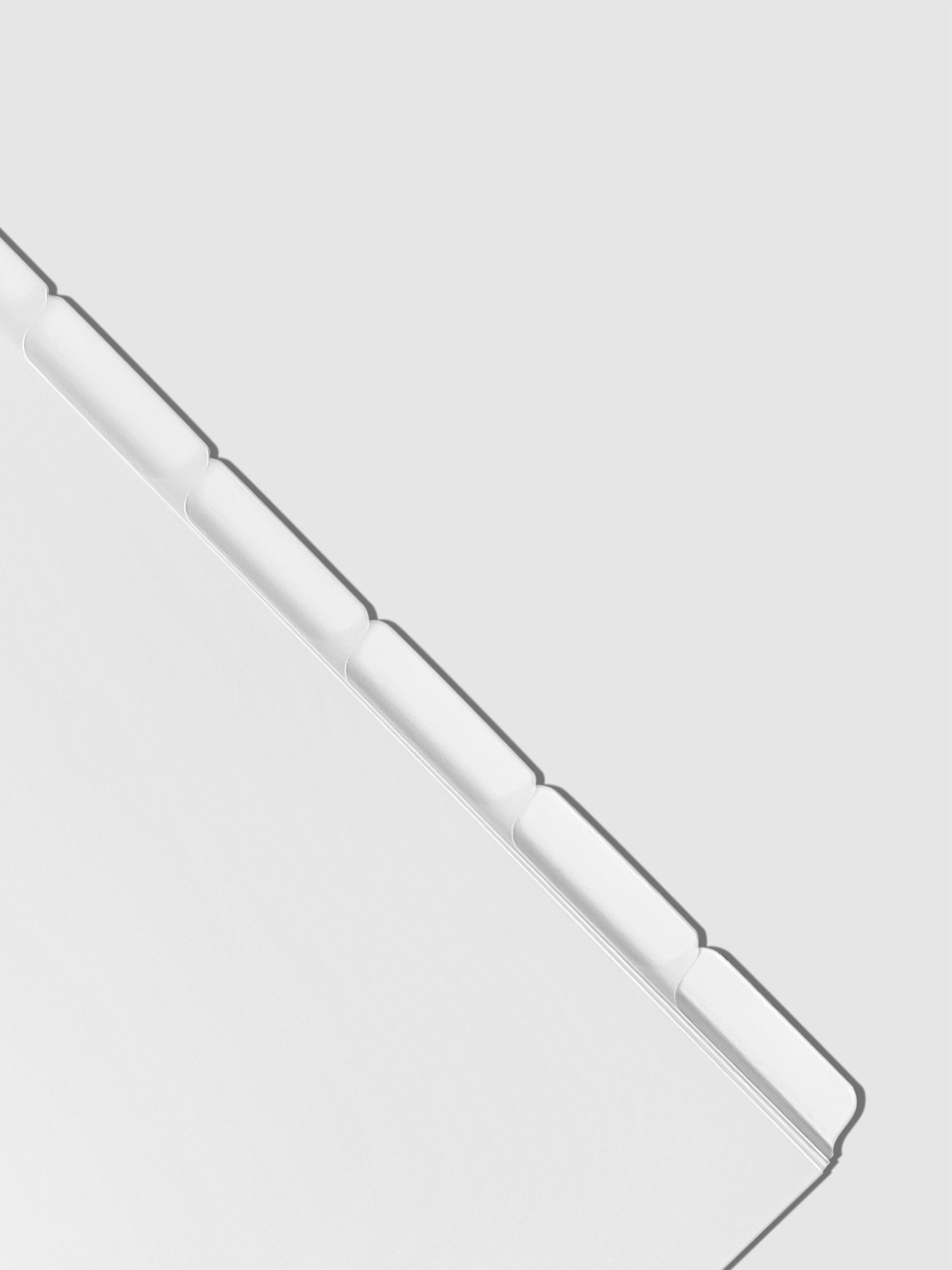 Closeup of blank divider tabs on a neutral background.