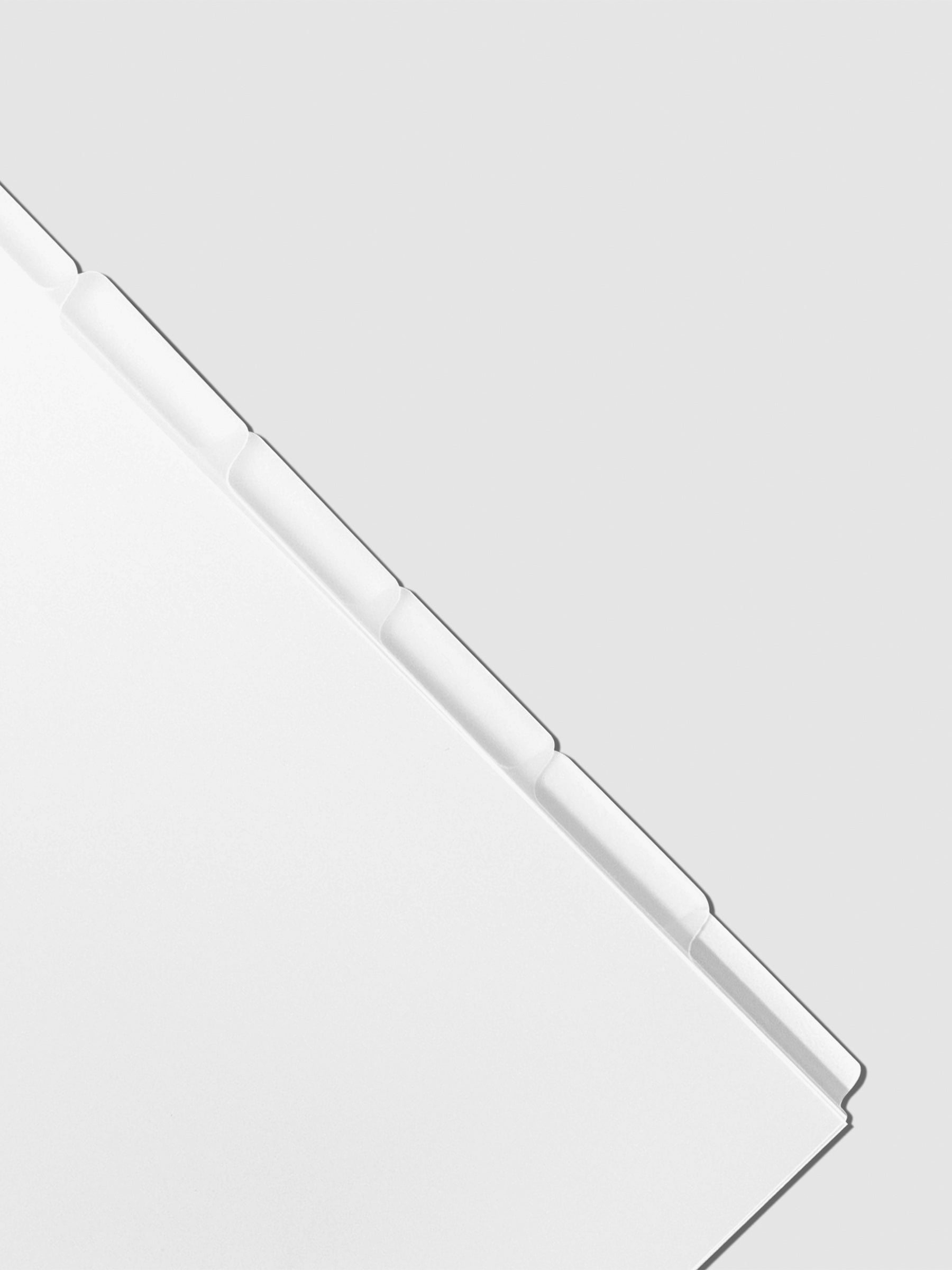 Closeup of Personal Wide blank divider tabs on a neutral background.