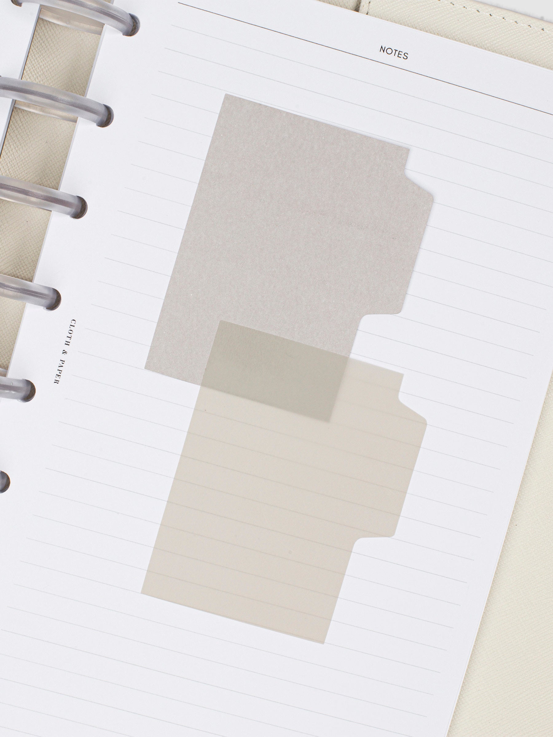 Blank Tab Sticky Note Set, Linen, Cloth and Paper. One matte and one transparent sticky note from the set placed on a task insert. The transparent sticky note is layered over the bottom right corner of the matte sticky note.