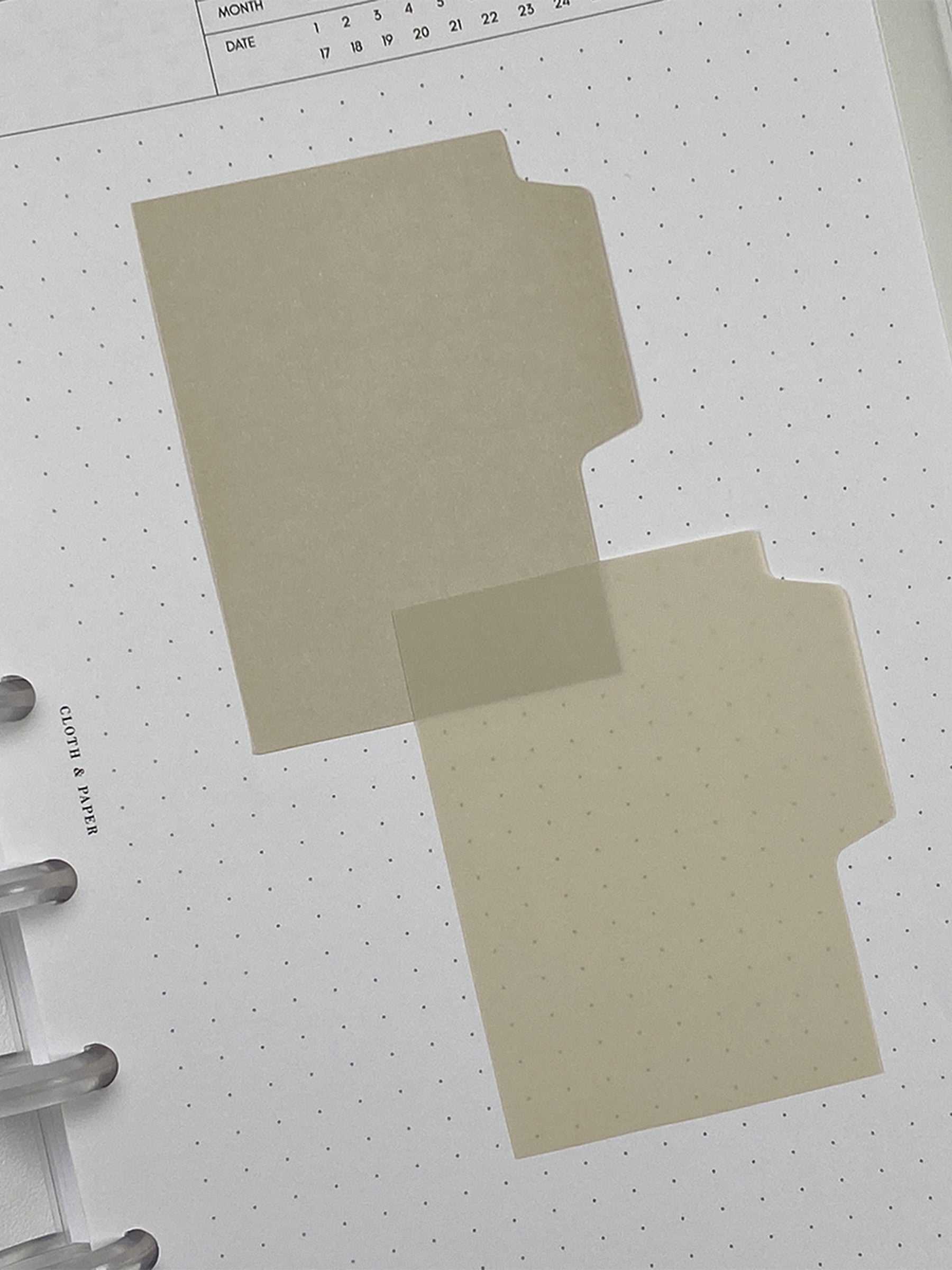 Blank Tab Sticky Note Set, Sand, Cloth and Paper. One matte and one transparent sticky note from the set placed on a task insert. The transparent sticky note is layered over the bottom right corner of the matte sticky note.