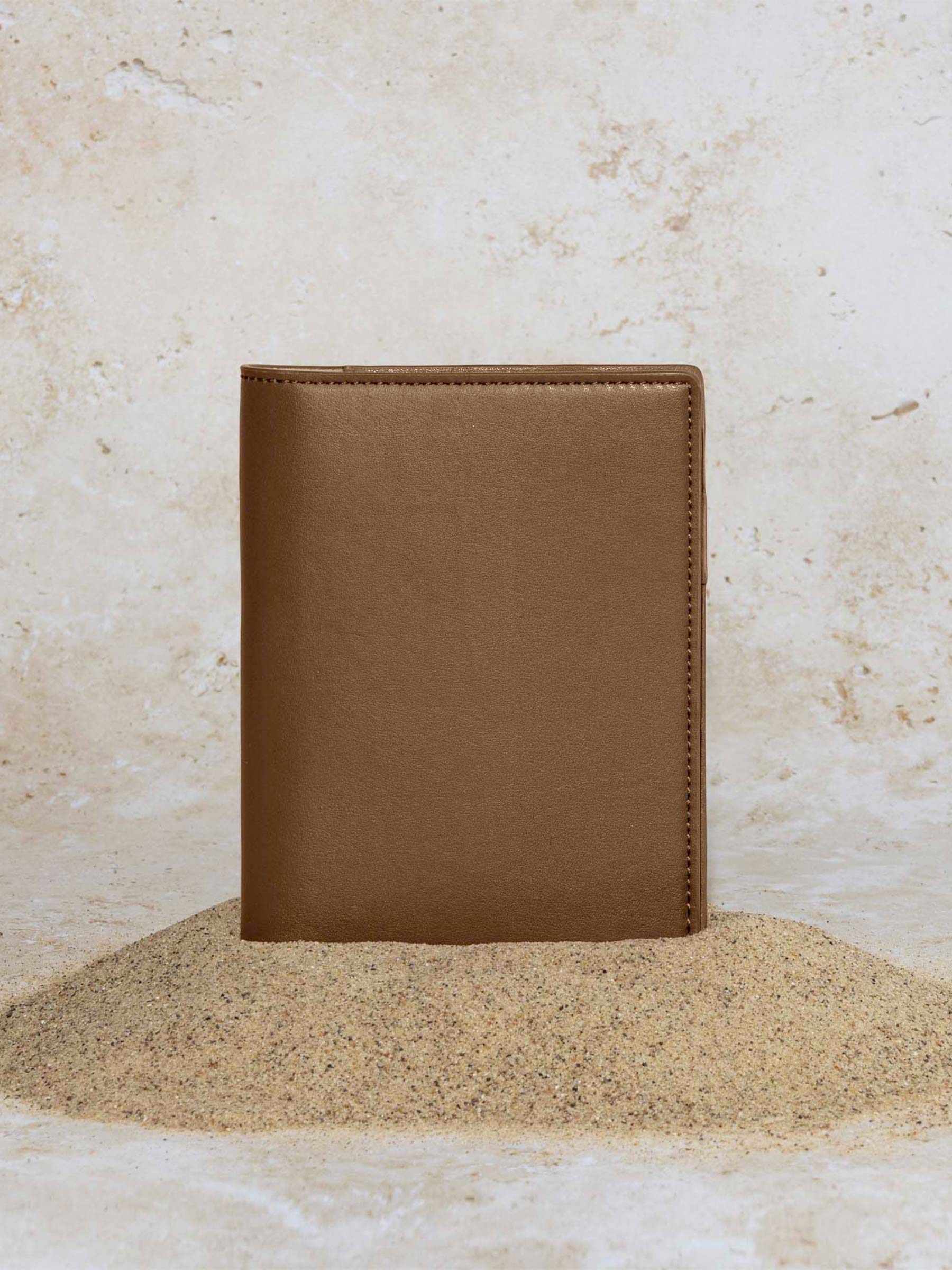 Cactus Vegan Leather Folio, CP Petite, Cloth and Paper. Folio displayed on a textured tan background, placed in a pile of sand. Color pictured is clay brown.
