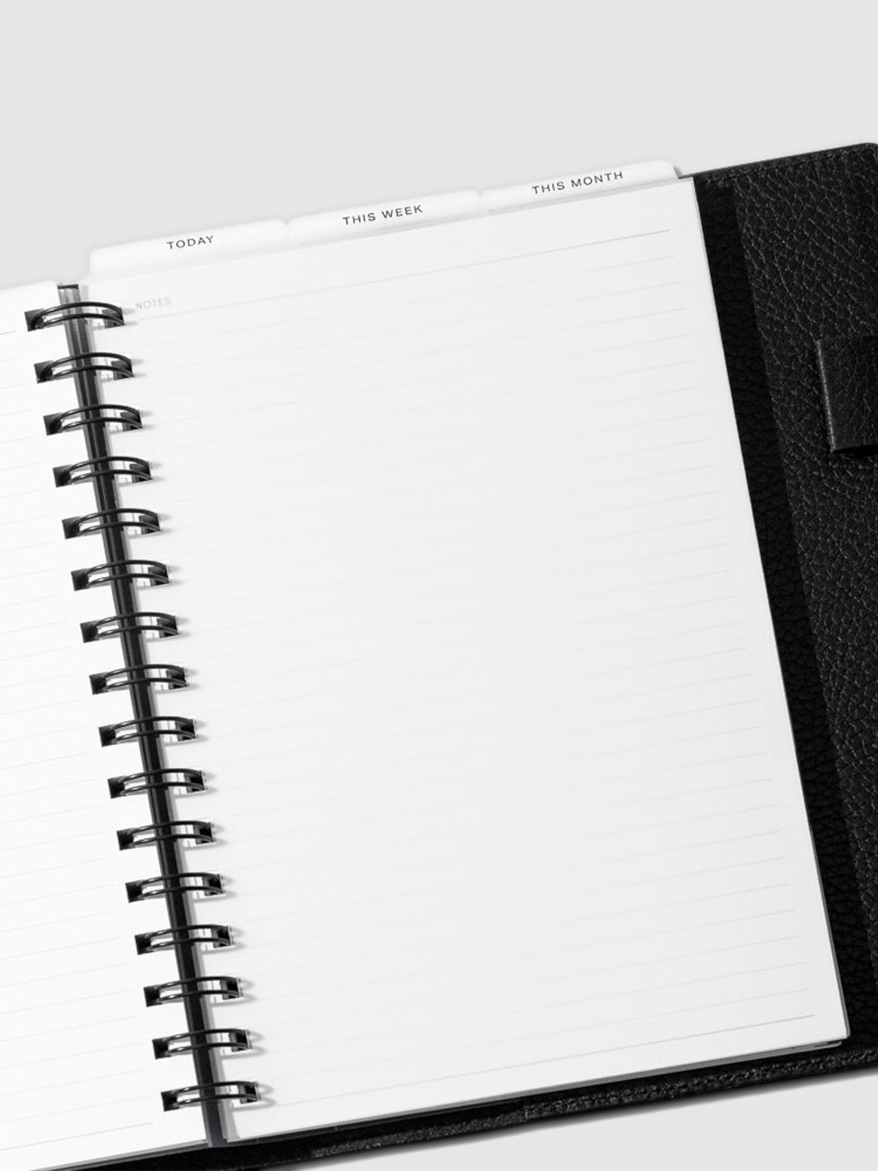 A5 Spiral Black Foil Cadence Tab Dividers displayed in a black leather planner.