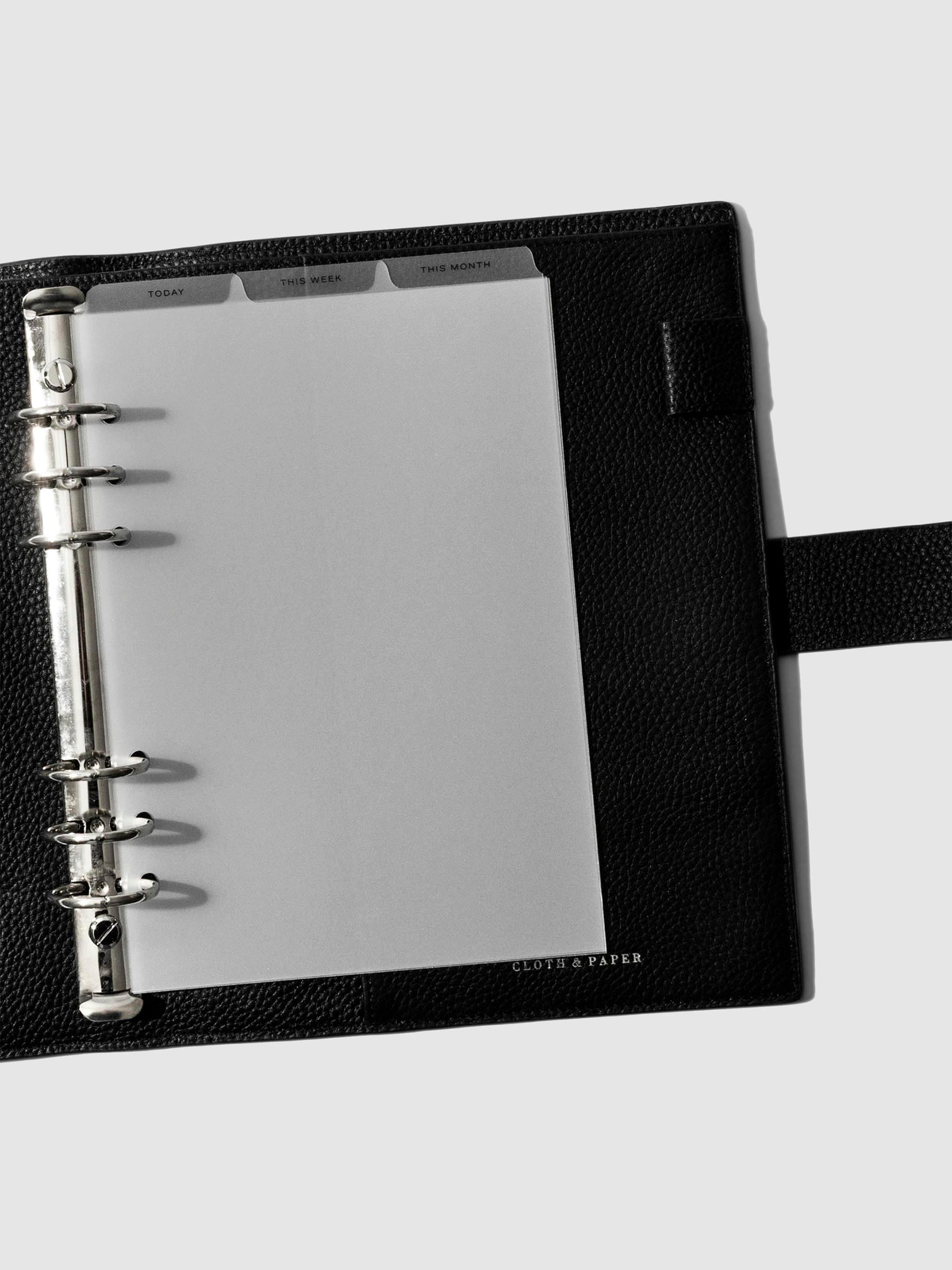 A5 6-Ring Black Foil Cadence Tab Dividers displayed in a black leather planner.