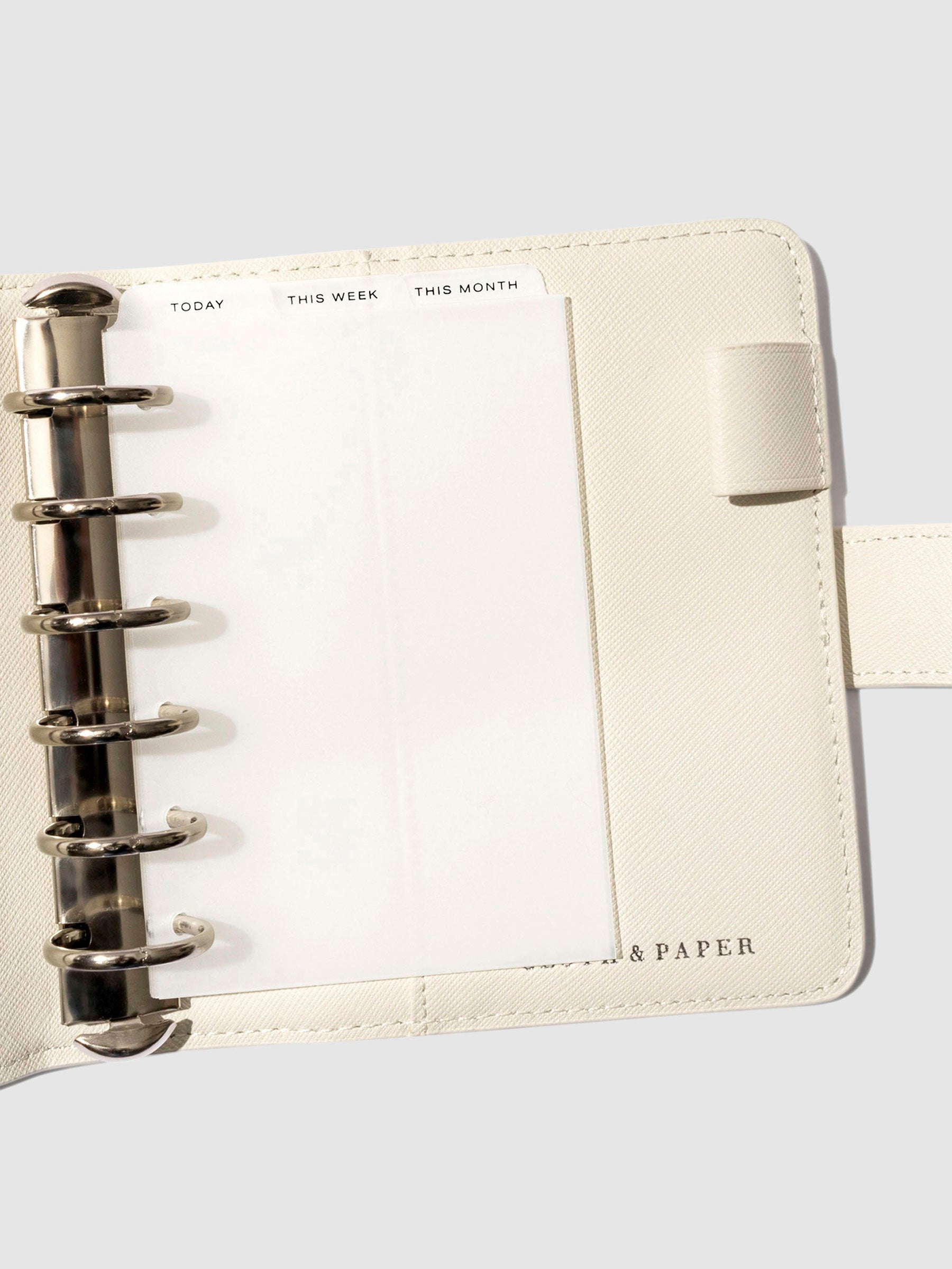 Pocket Black Foil Cadence Tab Dividers displayed in a white leather planner.