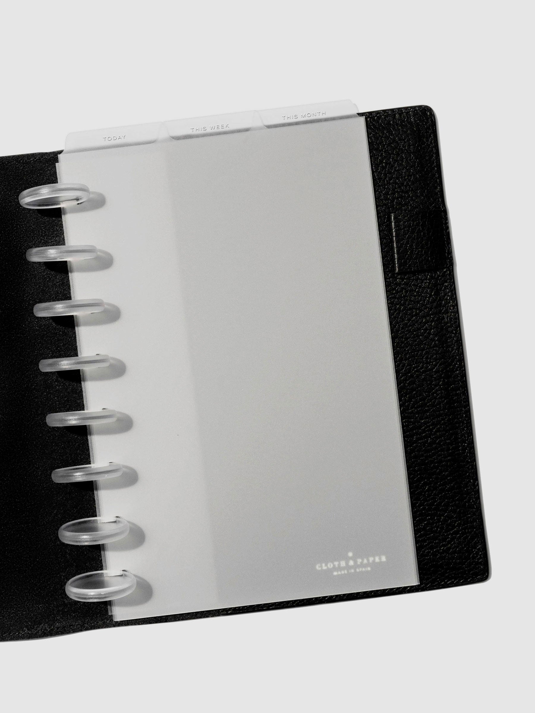 Half Letter White Foil Cadence Tab Dividers displayed in a black leather planner.