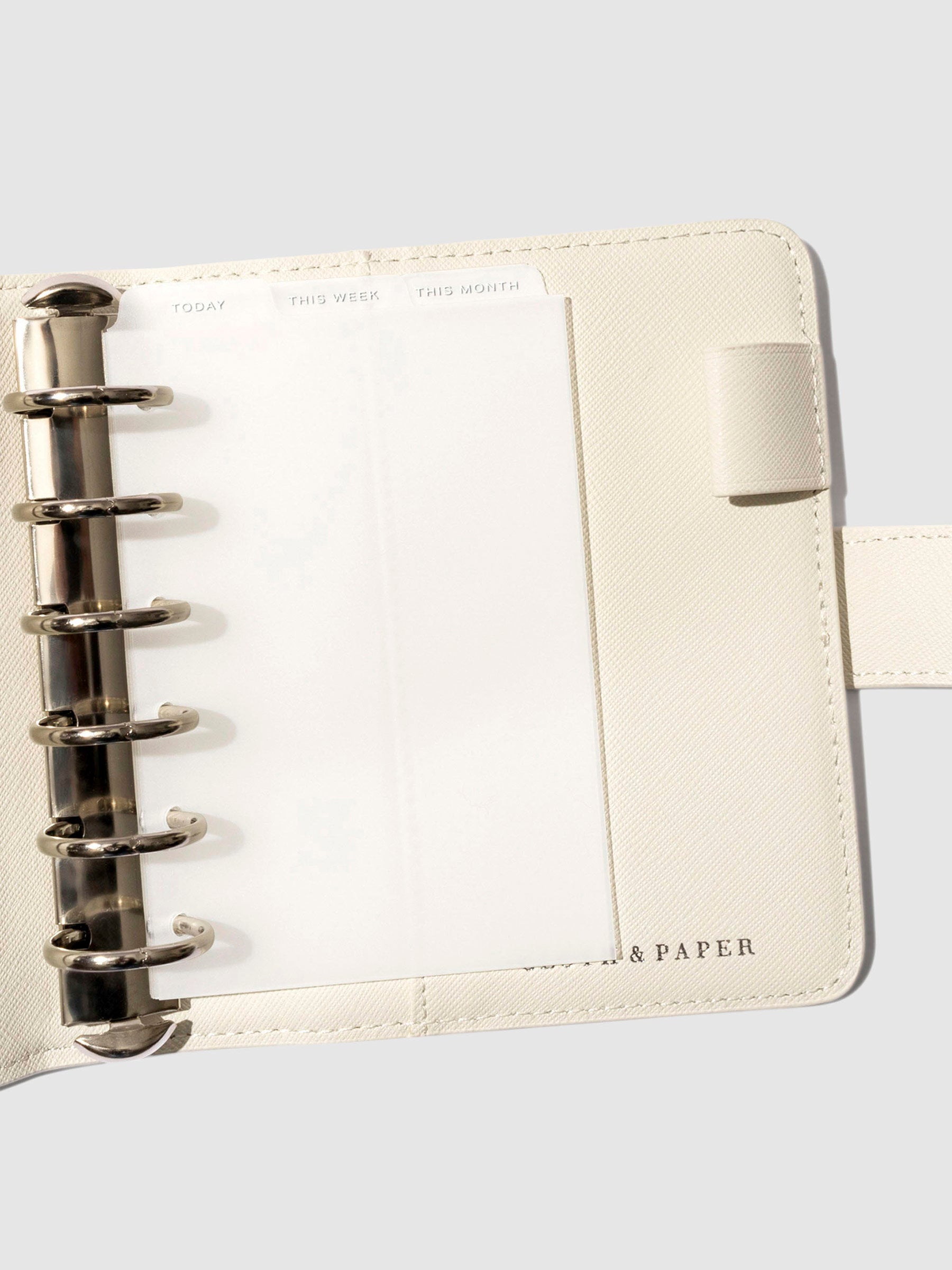 Pocket White Foil Cadence Tab Dividers displayed in a white leather planner.