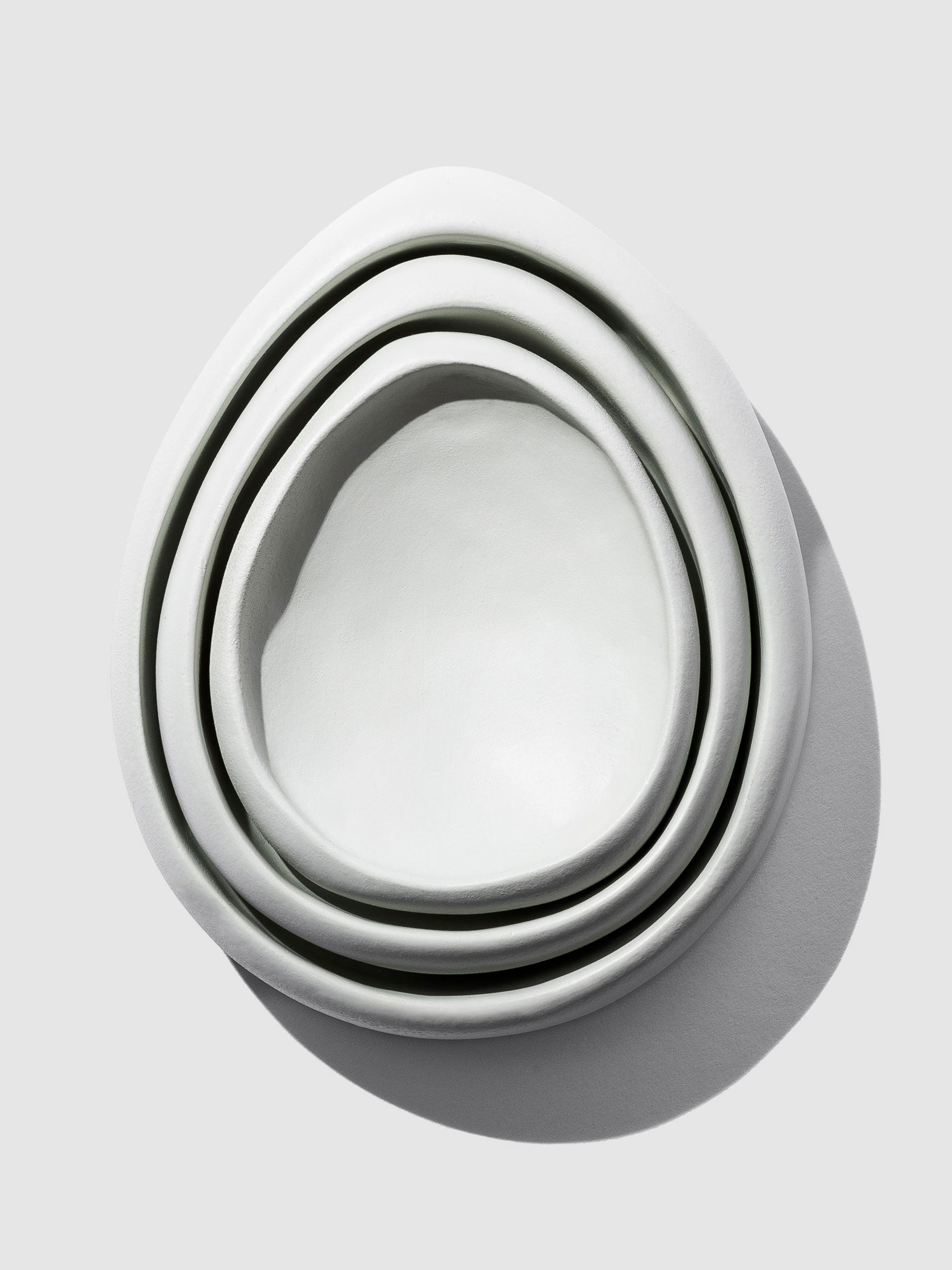 Nested set of 3 Catch-All Trays elegantly stacked against a clean neutral background, accentuated by subtle shadows, highlighting their versatile organization and minimalist design in a stylish arrangement.